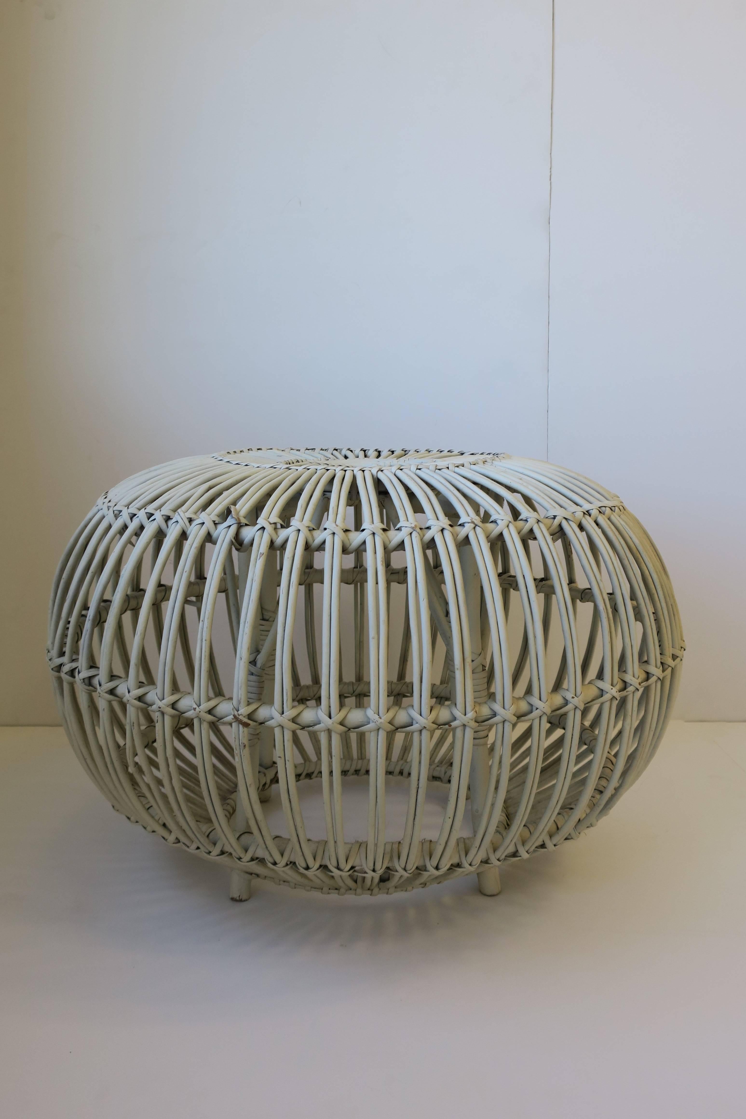A Mid-Century round white rattan stool or side table by designer Franco Albini. Piece can work as a stool/round bench, footstool, pouf/ottoman, or as a side table providing there is a book, tray, or glass top in place. Shown with book and coral in