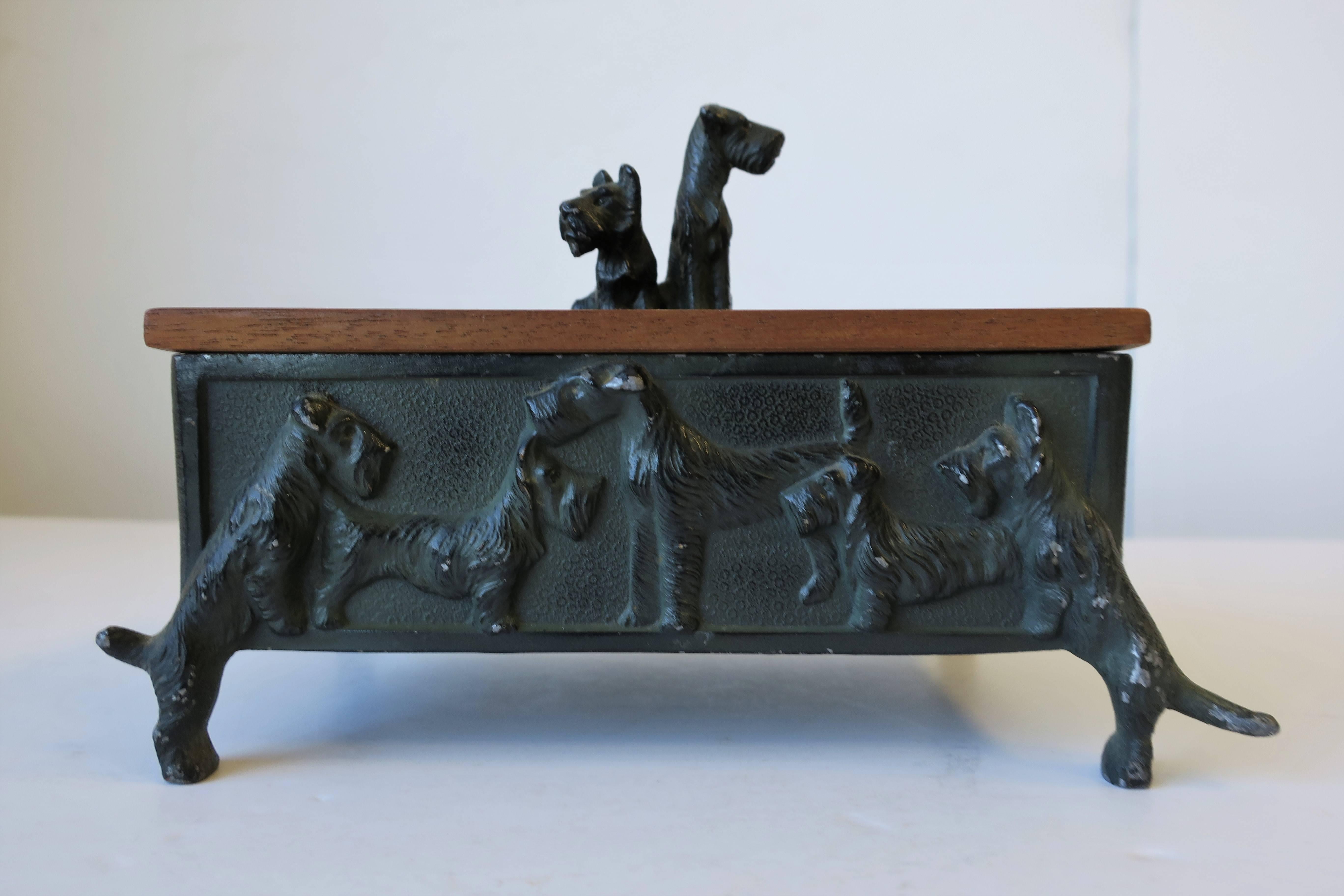 A substantial vintage iron and teak black Scottish Terrier 'Scottie' and Welch Terrier dog box, circa 1940s. Iron is painted in a black and dark or hunter green. Embossed Scottie and Welch terrier dogs surround outside of box. Teak wood interior and