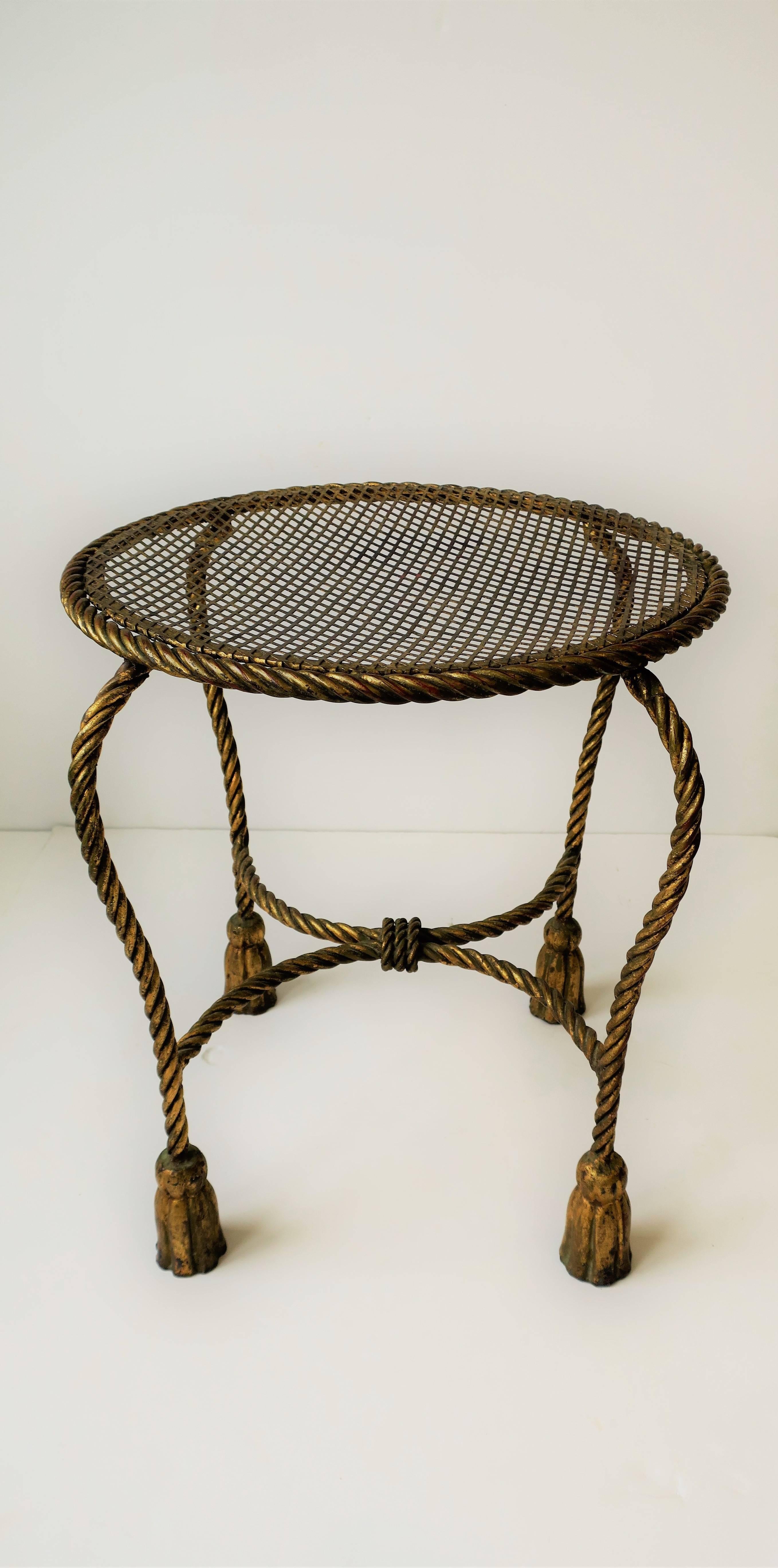 A mid-20th century Italian gold gilt metal stool or vanity seat/chair with a 'rope and tassel' design, decorative stretcher base. 

Piece measures: 17 in. H x 15.75 in. diameter. 

Item available here online. By request, item can be made available