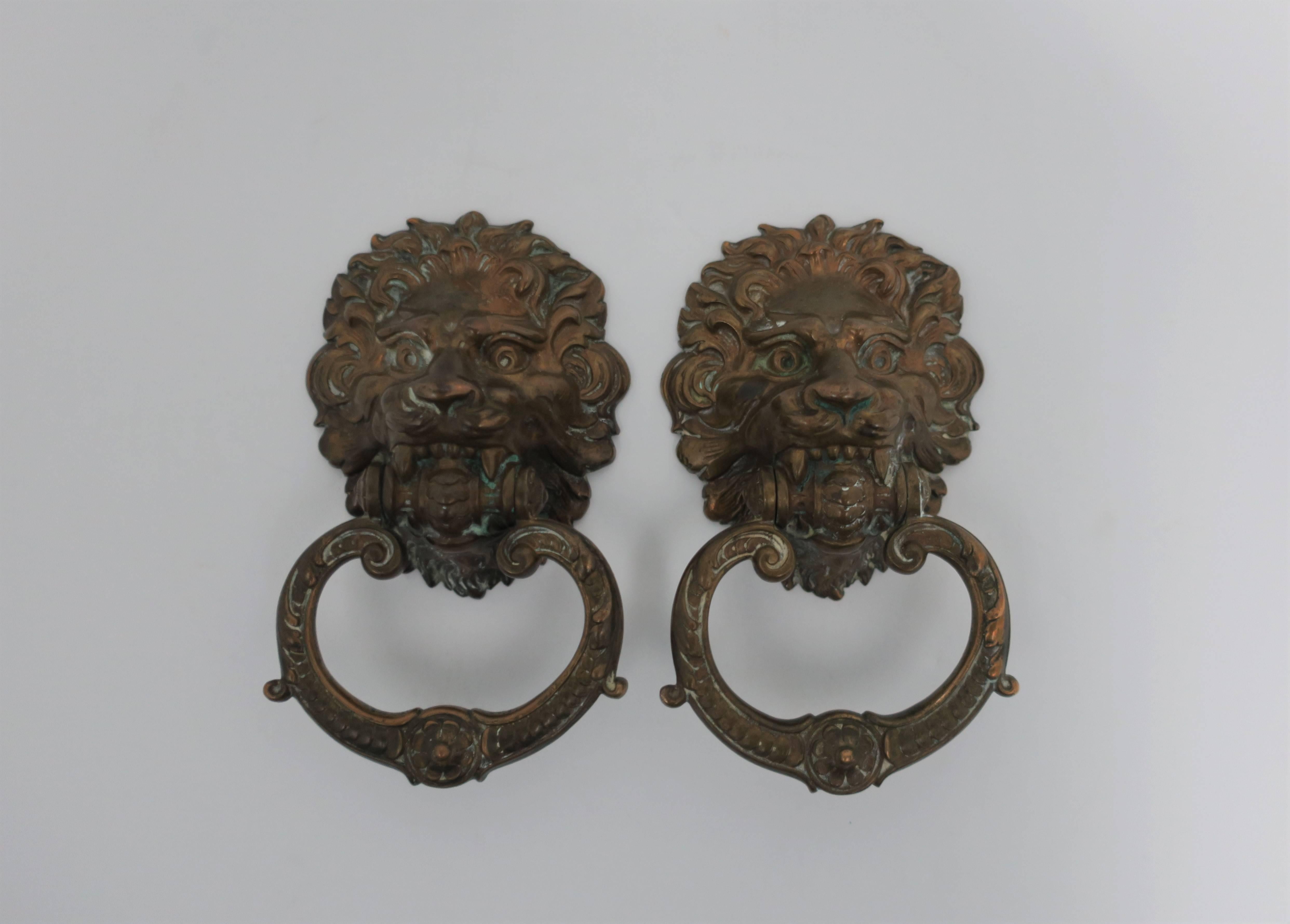 A beautiful, substantial, and detailed pair of vintage bronze neoclassical style lion head hardware door knockers. Detailed bronze: face, hair, eyes, nose, jaw and knocker ring. 

Each measure: 6.5 in. H x 3.5 in. W x 2 in. D. 

Pair available here