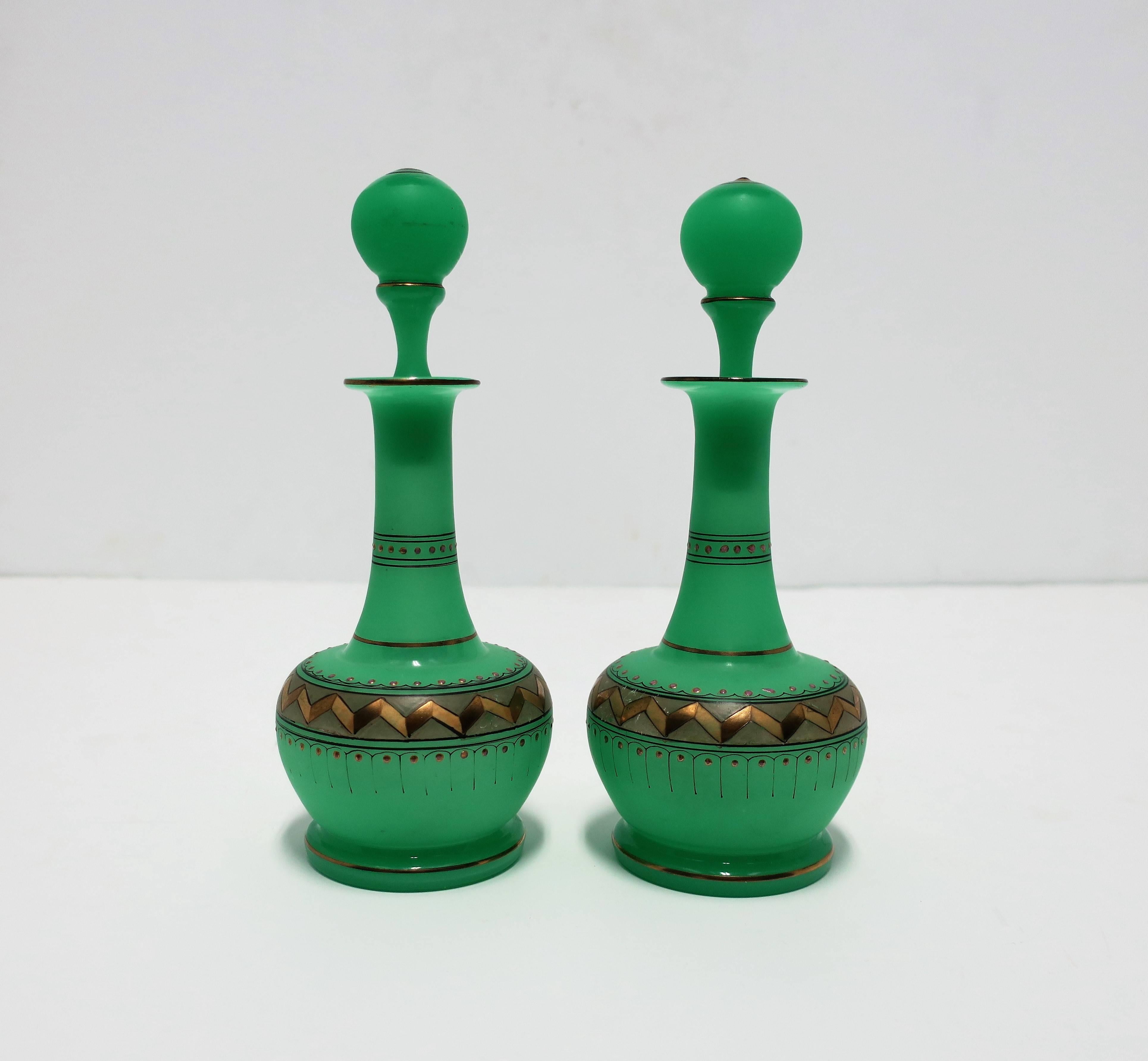 A gorgeous pair of Italian emerald green or 'Kelly' green opaline glass vanity perfume bottles or vessels, circa 1930s, Italy. Bottles have a beautiful gold chevron pattern design. Each numbered on bottom: 38 and 39 respectively. Colors include: