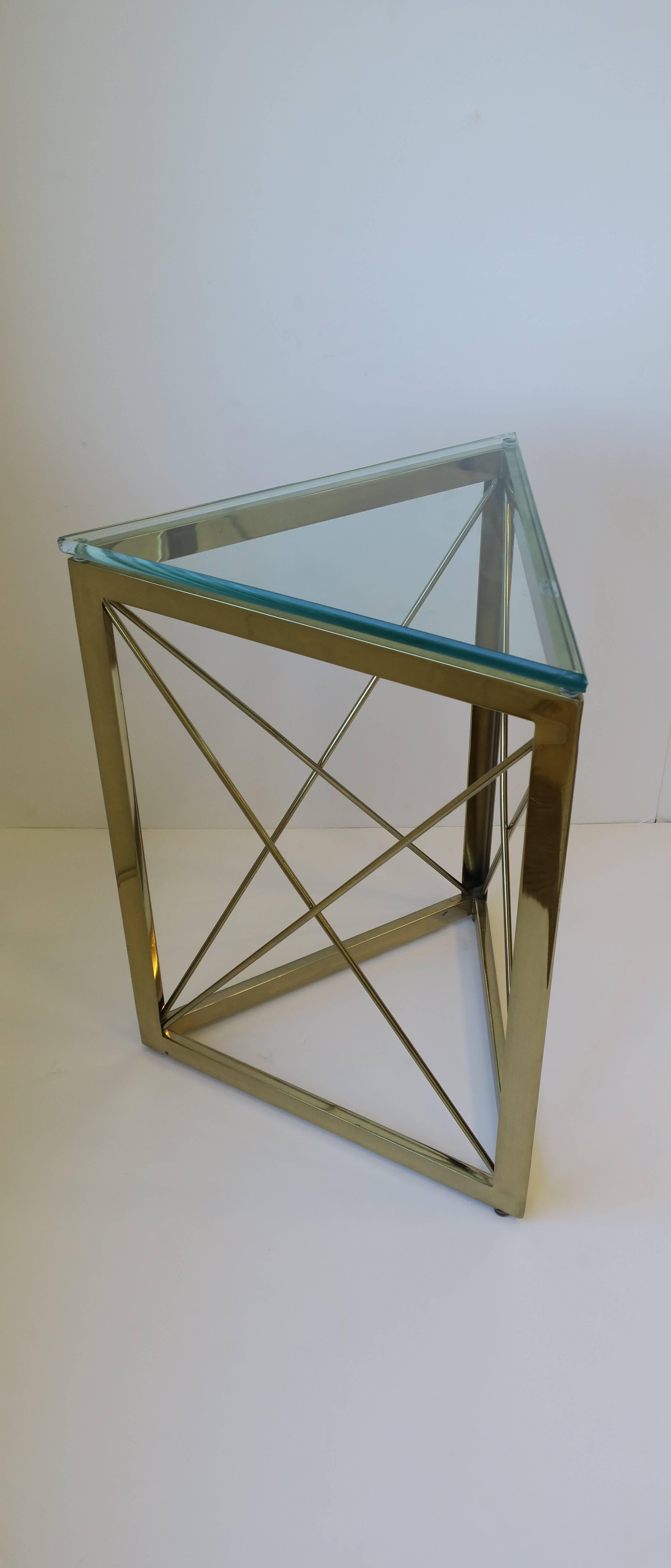 A beautiful and unique Modern style triangle shaped brass and glass side or drinks table with X-design base on all three sides. Glass top measures 1/2 in. thick; glass is tempered. 

Table measures: 16 in. x 16 in. x 16 in x 21.25 in. H. 

