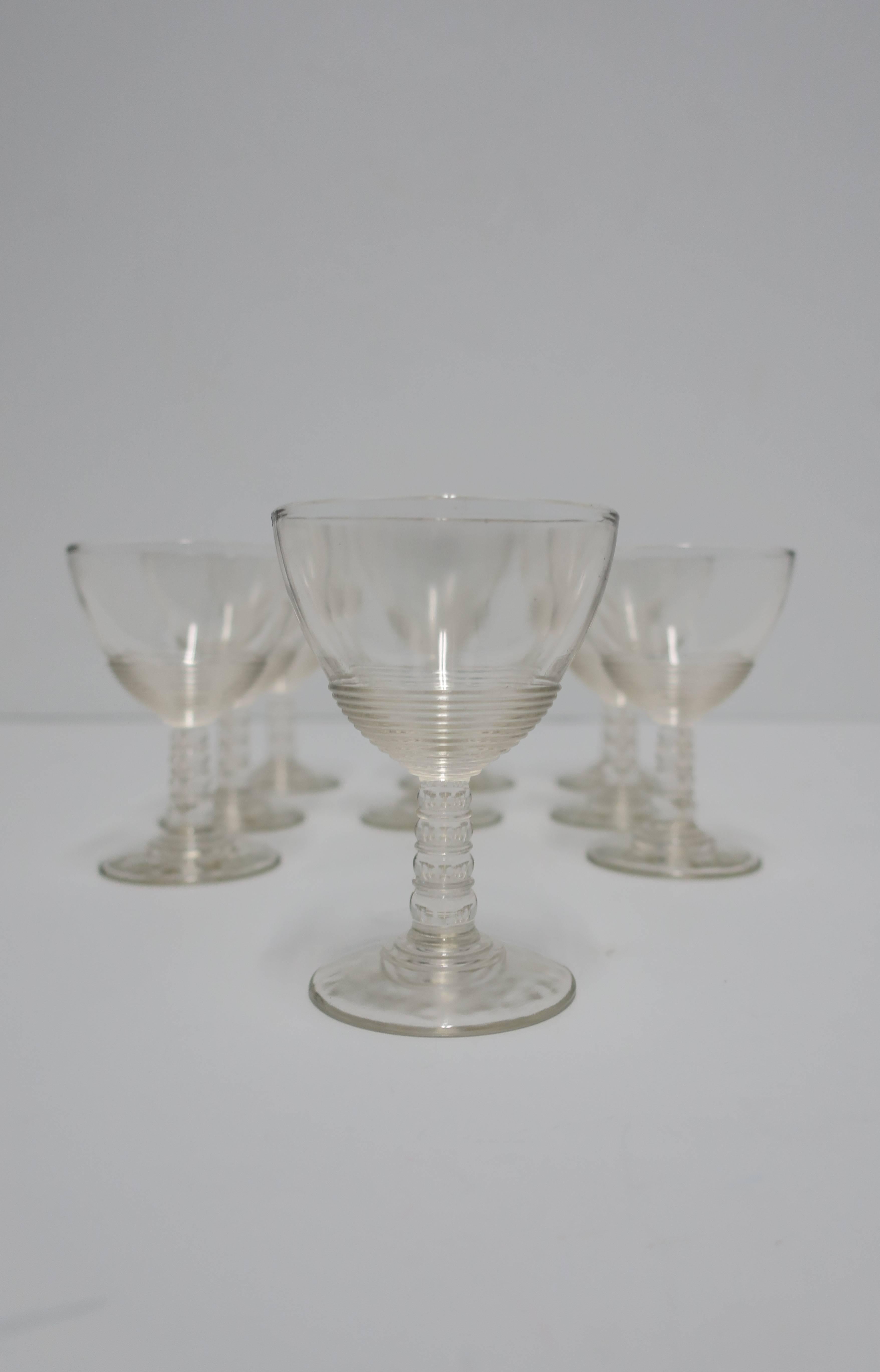 A set of nine (9) Modern clear glassware set with ribbed detailing and ball stem, circa 1920s. Great for any beverage including Champagne, wine, spirit, etc. Each measure 4