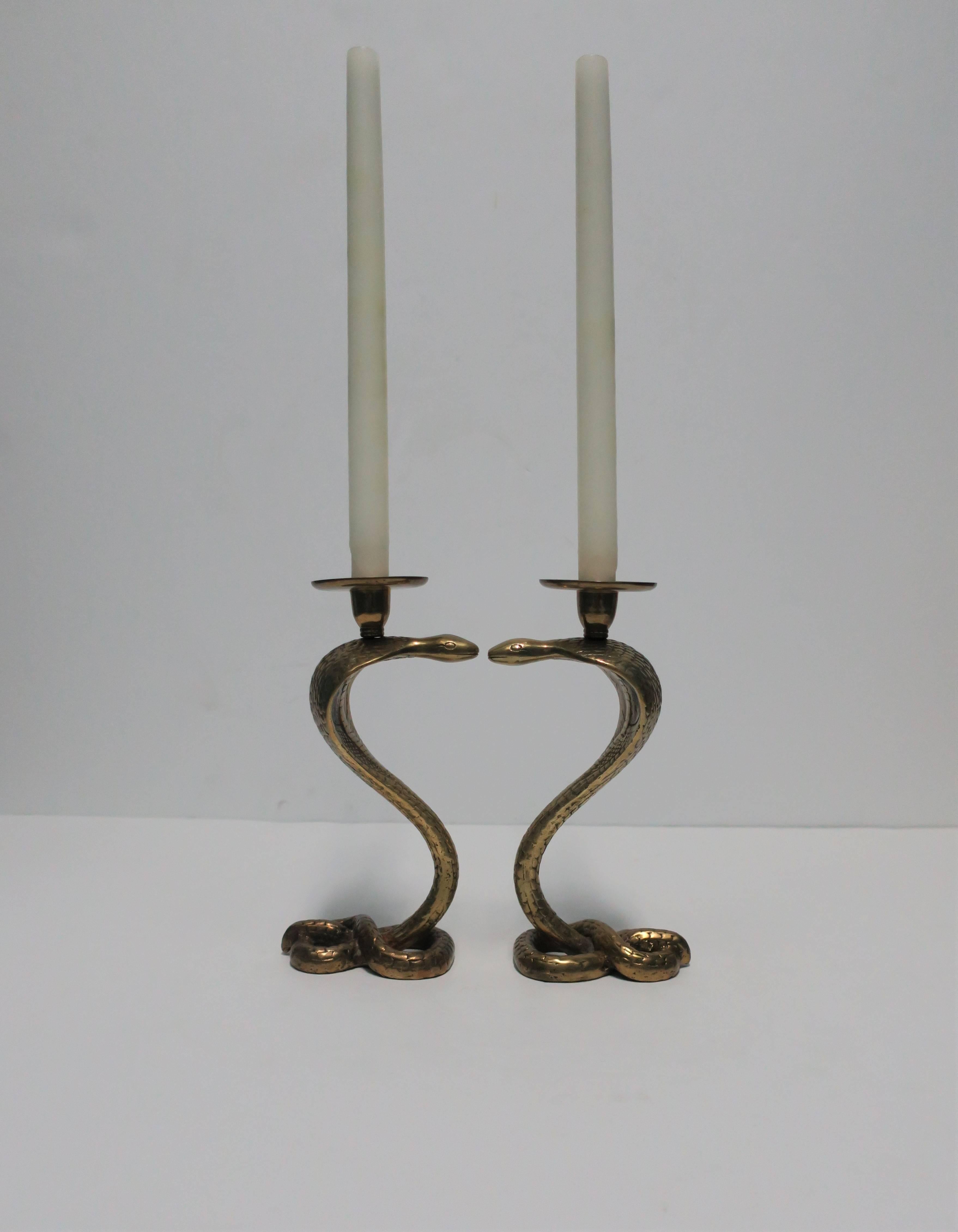 A striking pair of solid brass Cobra snake sculpture candlestick holders. Beautiful details from base to top, with brass resembling snakeskin look and feel.

Each measure: 8.75 in. H x 4 in. x 2.5 in. 

Pair available here online. By request, pair