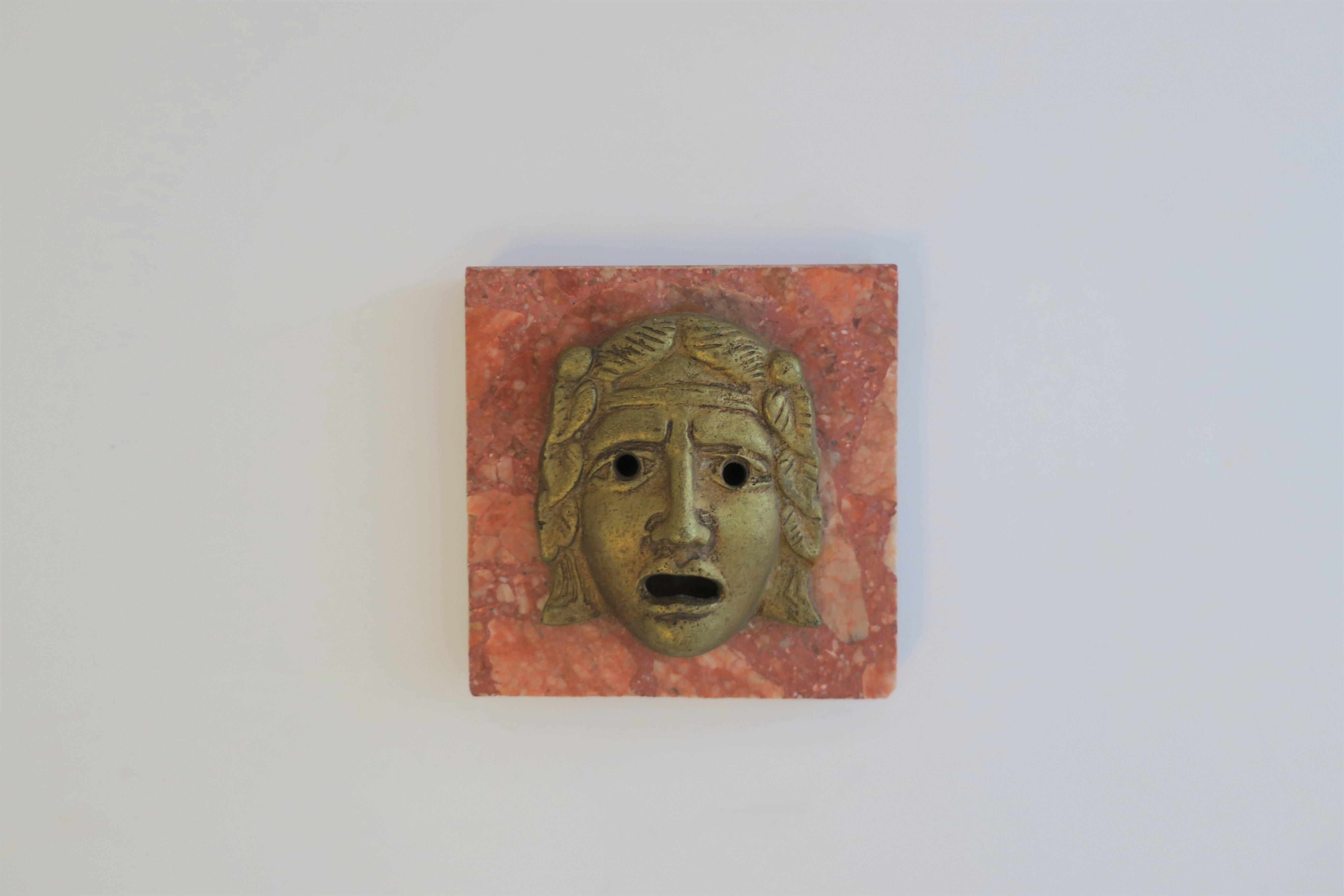 A classical Roman style God or Medusa brass face sculpture on orange/red marble base; beautiful decorative object, paperweight, or deck accessory, circa early - Mid-20th century, Italy. 

Piece measures: 3.88 in. W x 4 in. D x 1.50 in. H

Also