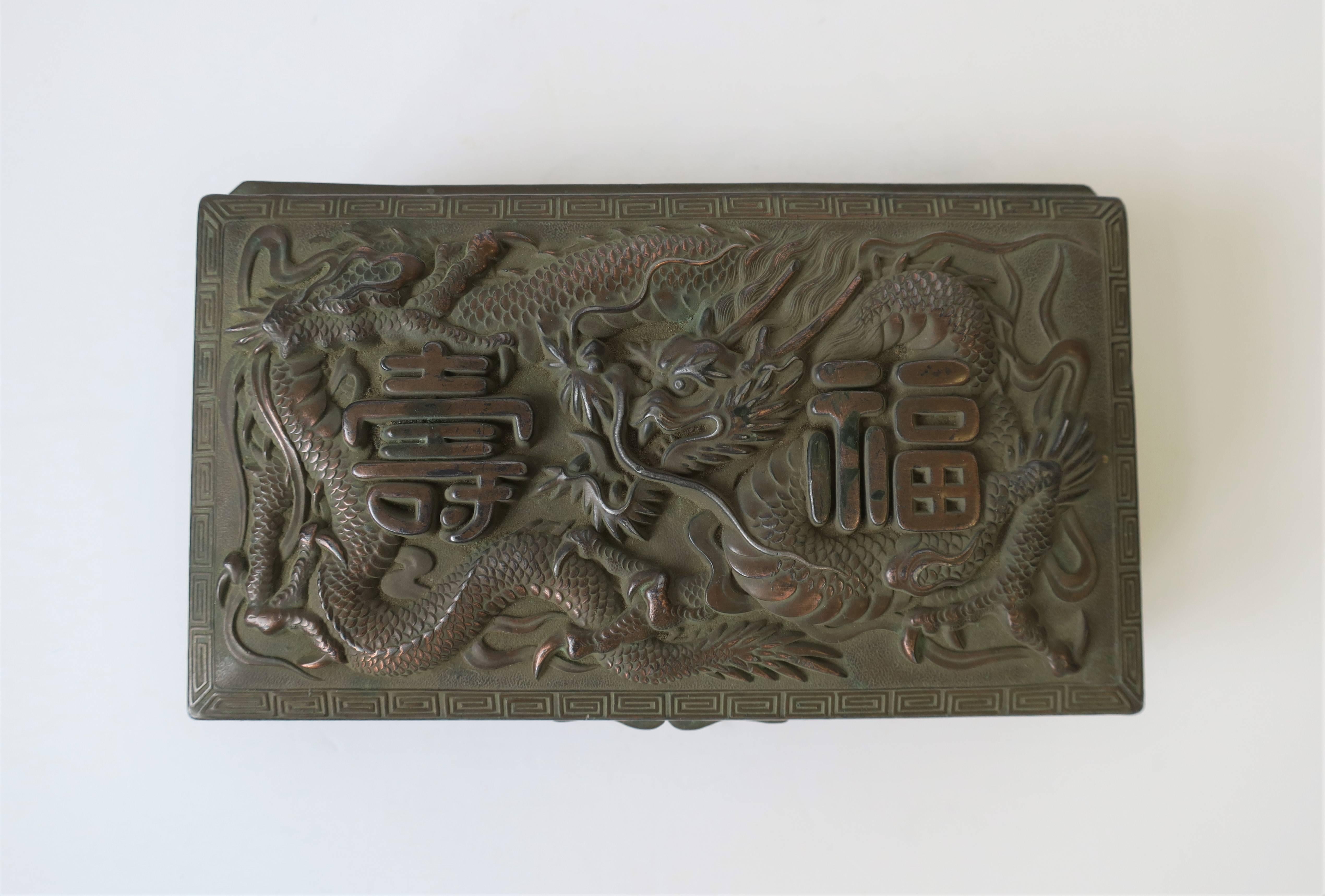 A beautiful and substantial copper metal Japanese box with elaborate raised, debossed or 'repousse' design: elaborate dragon, Japanese writing, Greek Key-like detail on top edge, and mum flowers on sides. Early 20th century Japan, circa 1940s WWII