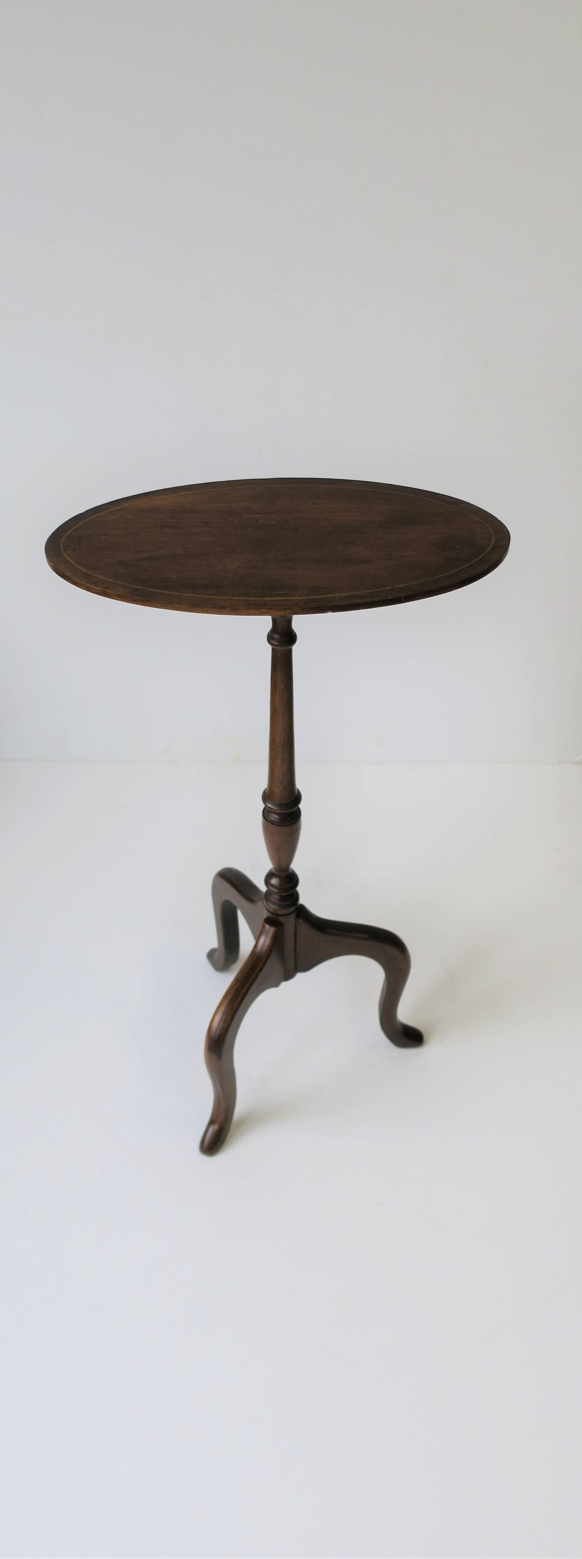 A beautiful Queen Anne Mahogany 'tilt-top' 'candle stand' or side table with satinwood inlay on oval tabletop, circa early 20th Century, England.

Table measures: 24.75 in. H x 13 in. x 6.63 in.

 