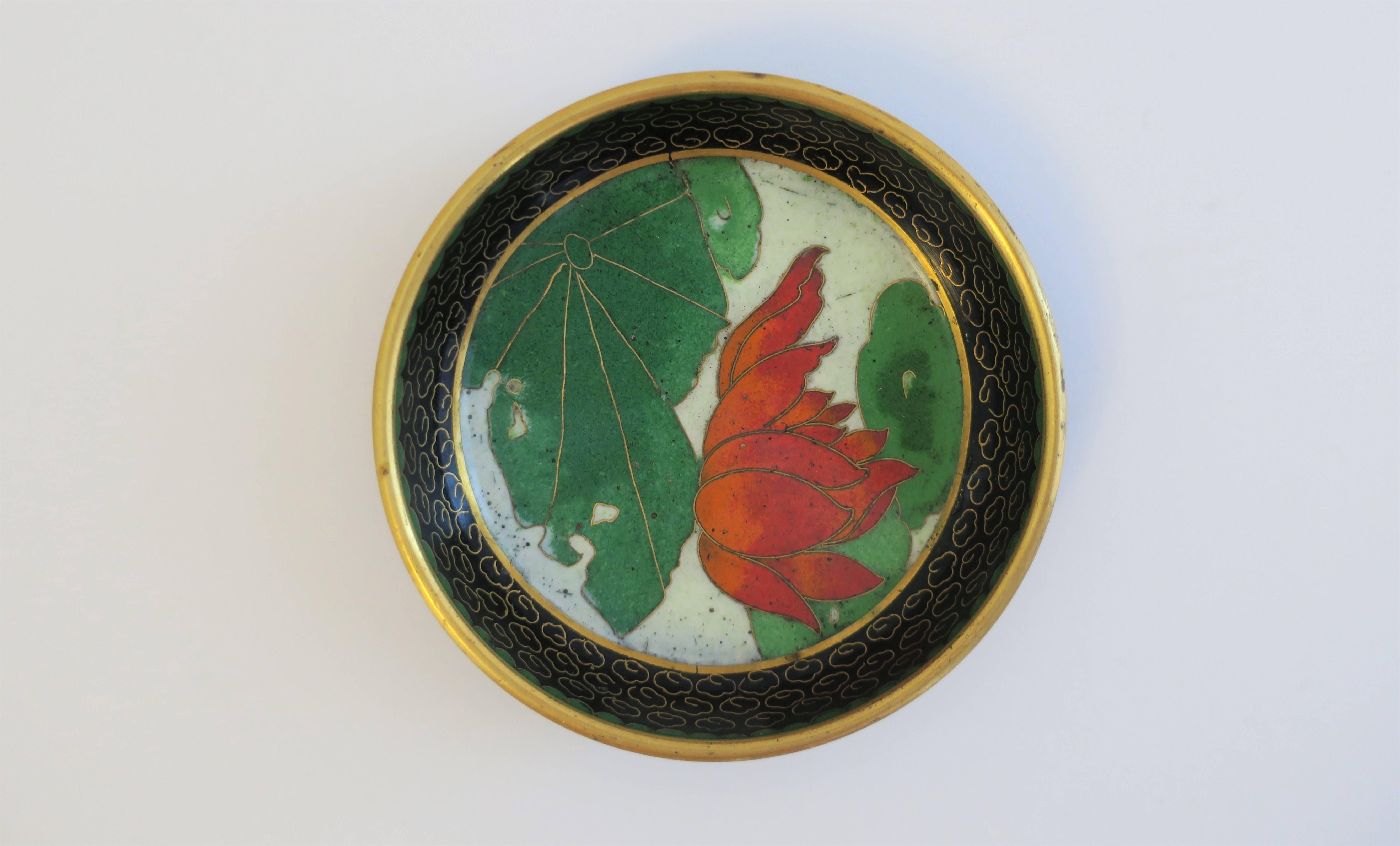 A beautiful vintage Chinese cloisonné trinket or jewelry dish or bowl, with a floral and leaf design. Piece is brass with black, white, emerald green, and red Cloisonné enamel, and a cobalt or royal blue underside. 

Piece measures: 1 in. height x