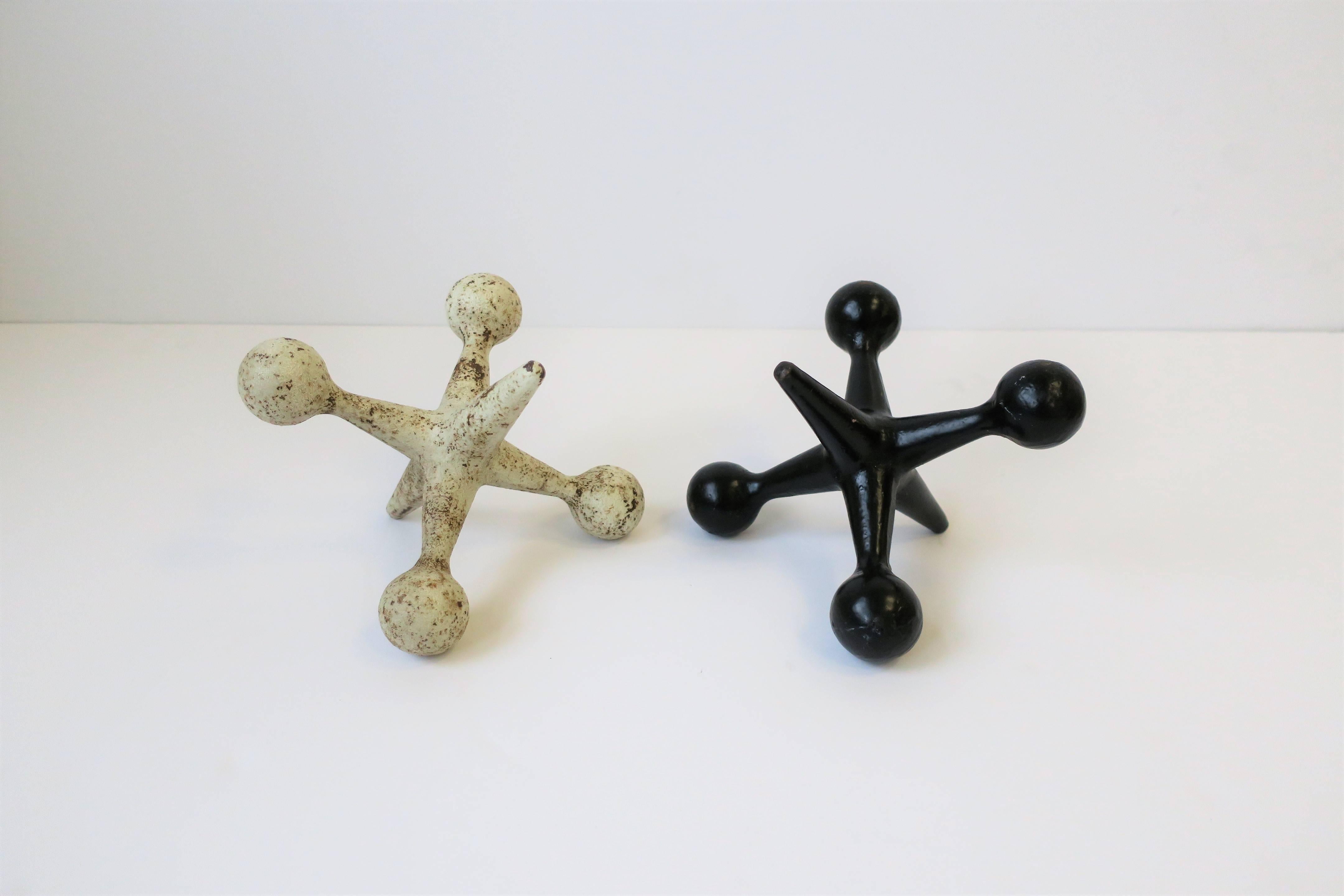 A substantial pair of 20th century black and white metal iron jacks. Each jack can serve as a bookend or standalone decorative object as show in images. 

Small Italian side table shown in images 8-10, search ref. no.: LU131428676143 (SOLD.)

