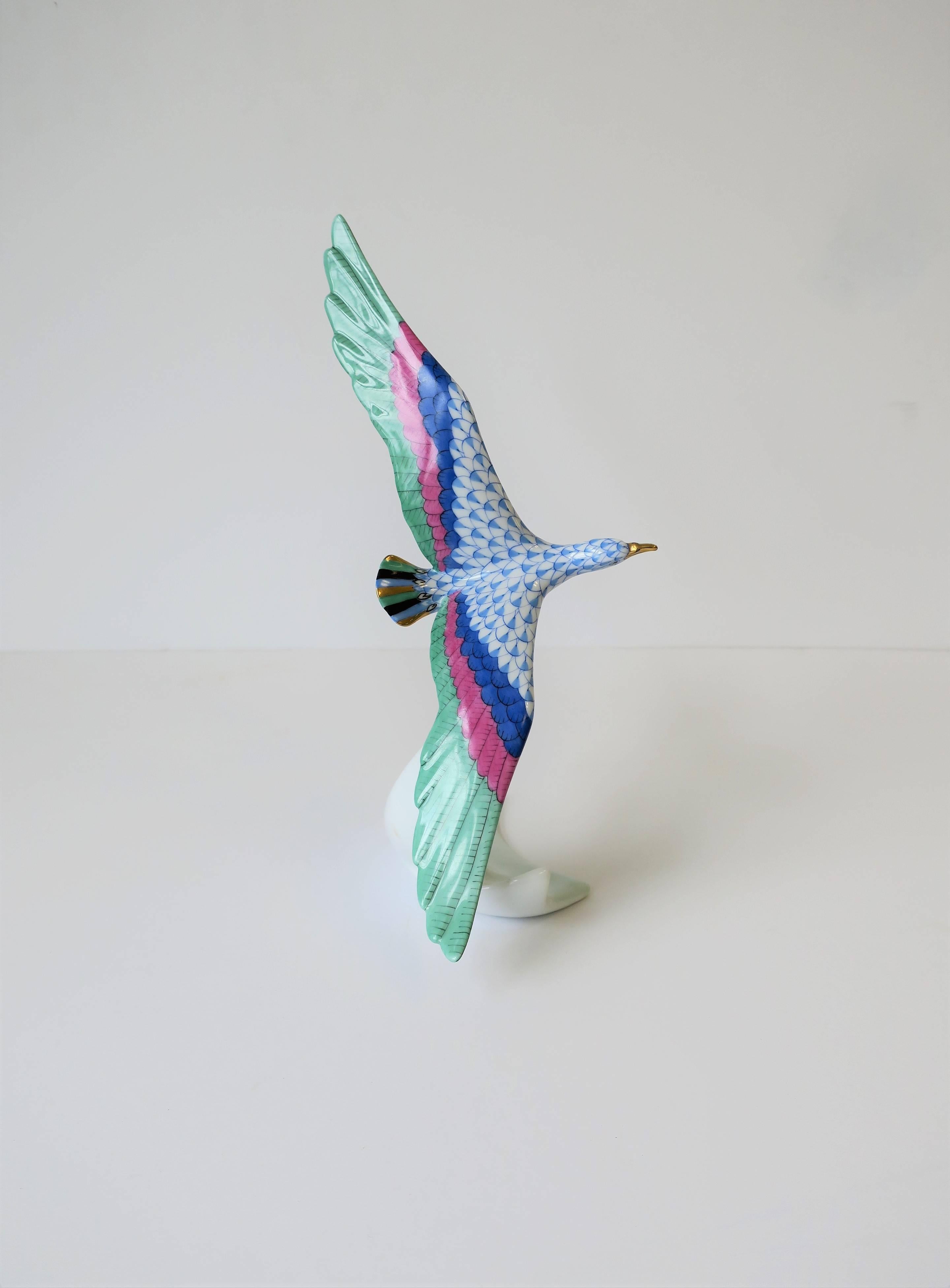 A gorgeous blue and white porcelain bird-in-flight sculpture decorative object by luxury maker, Herend, from Hungary. Bird bears the beautiful iconic Herend pattern on body, detailed gold accent on birds bill and feet, and black and gold on tail.