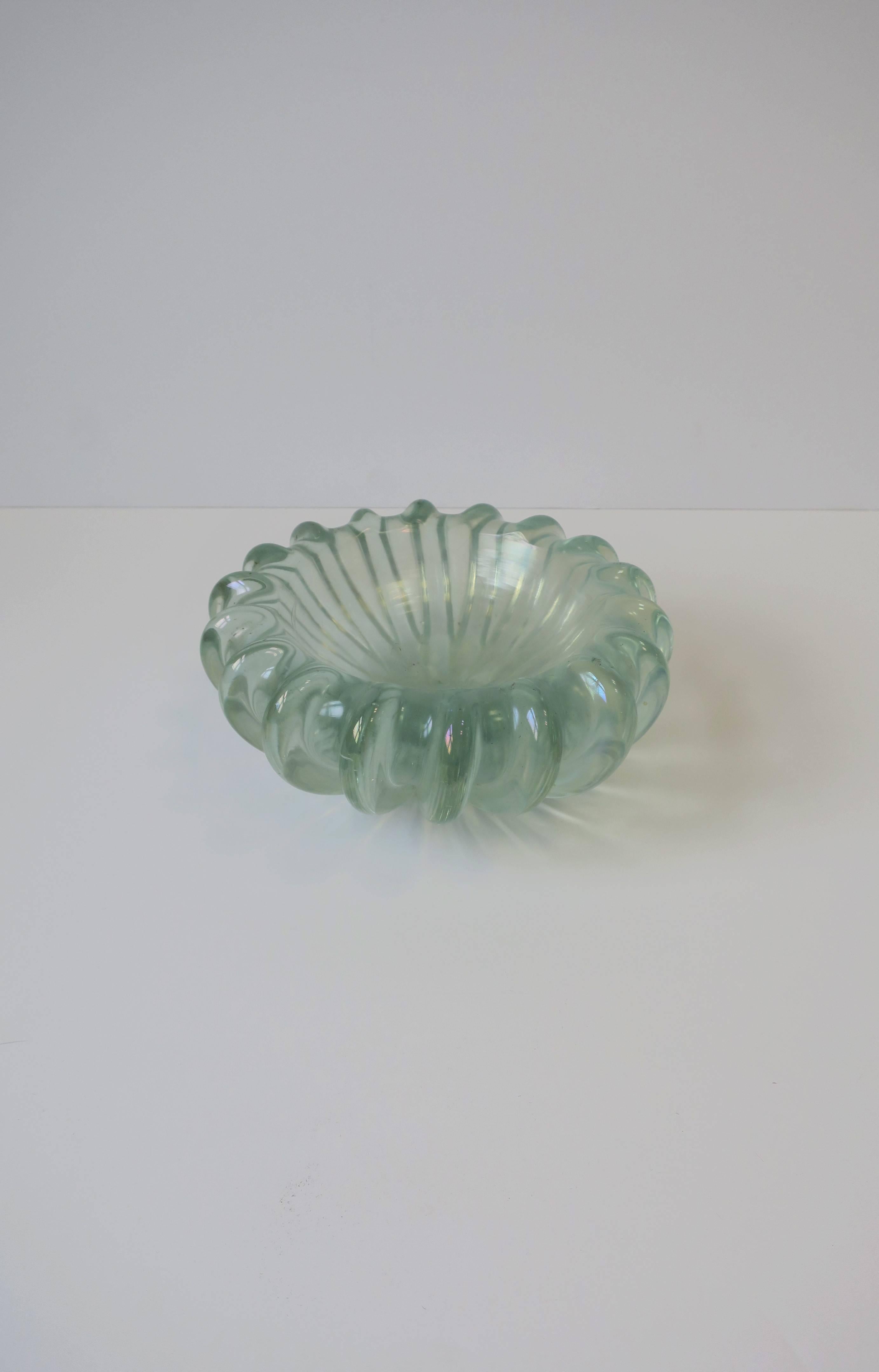 Il s'agit d'un très important et magnifique bol en verre d'art irisé de Murano avec un design cannelé, vers le milieu du 20e siècle, Italie. La teinte du verre d'art est un vert mousse de mer clair translucide avec une irisation chatoyante. Le bol