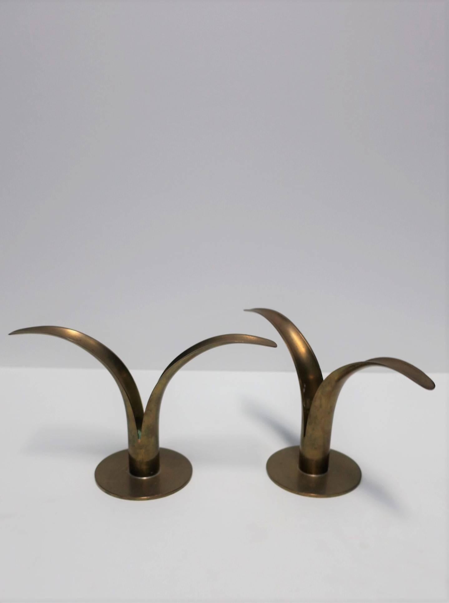 A pair of iconic Scandinavian Modern brass candlesticks designed by Ivar Alenius-Bjork for Ystad Metall of Sweden, circa mid-20th century, Sweden. With designers mark and maker's mark on bottom as show in image #8. Pair shown unpolished with