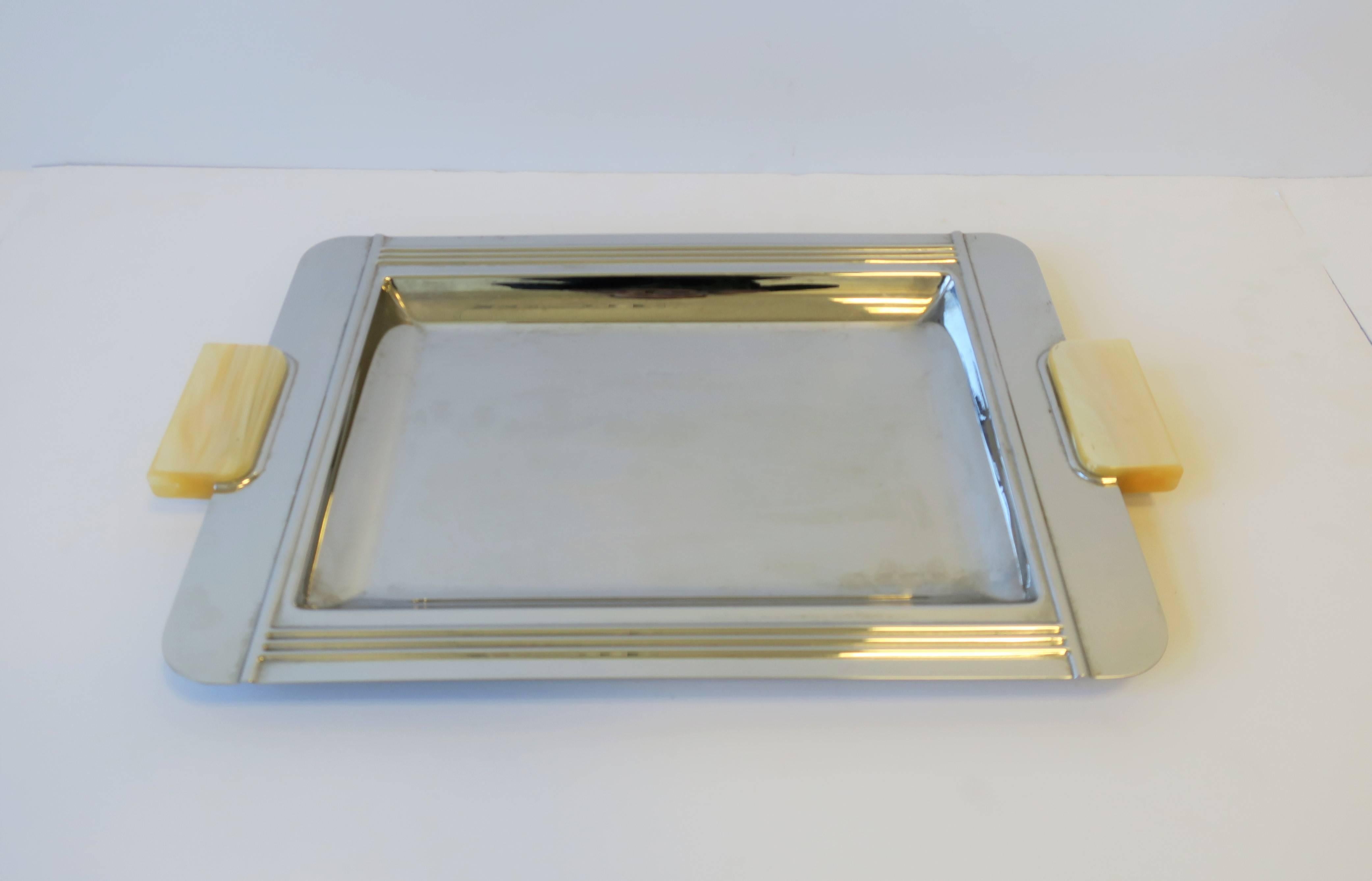 A beautiful French Art Deco style chrome serving tray. Tray has iconic Art Deco lines and beautiful cream colored resin handles. Vintage onyx coaster set featured also available for purchase, search ref. no.: LU131428847663

Tray measures: 11.25 in.