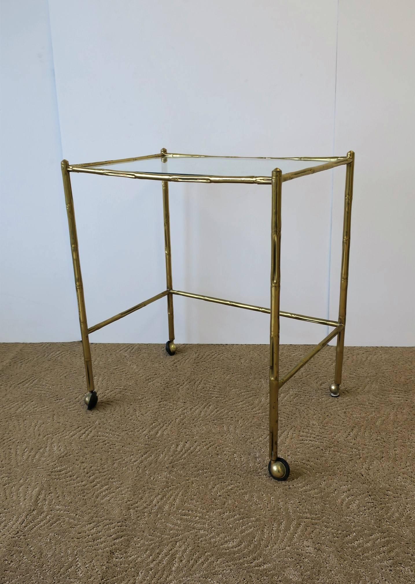 An Italian brass and glass bar cart table, circa early to mid-20th century, Italy, circa 1940s. Tables brass 'bamboo' style frame is light weight with a nicely weighted inset glass top. Dimensions: 20.75