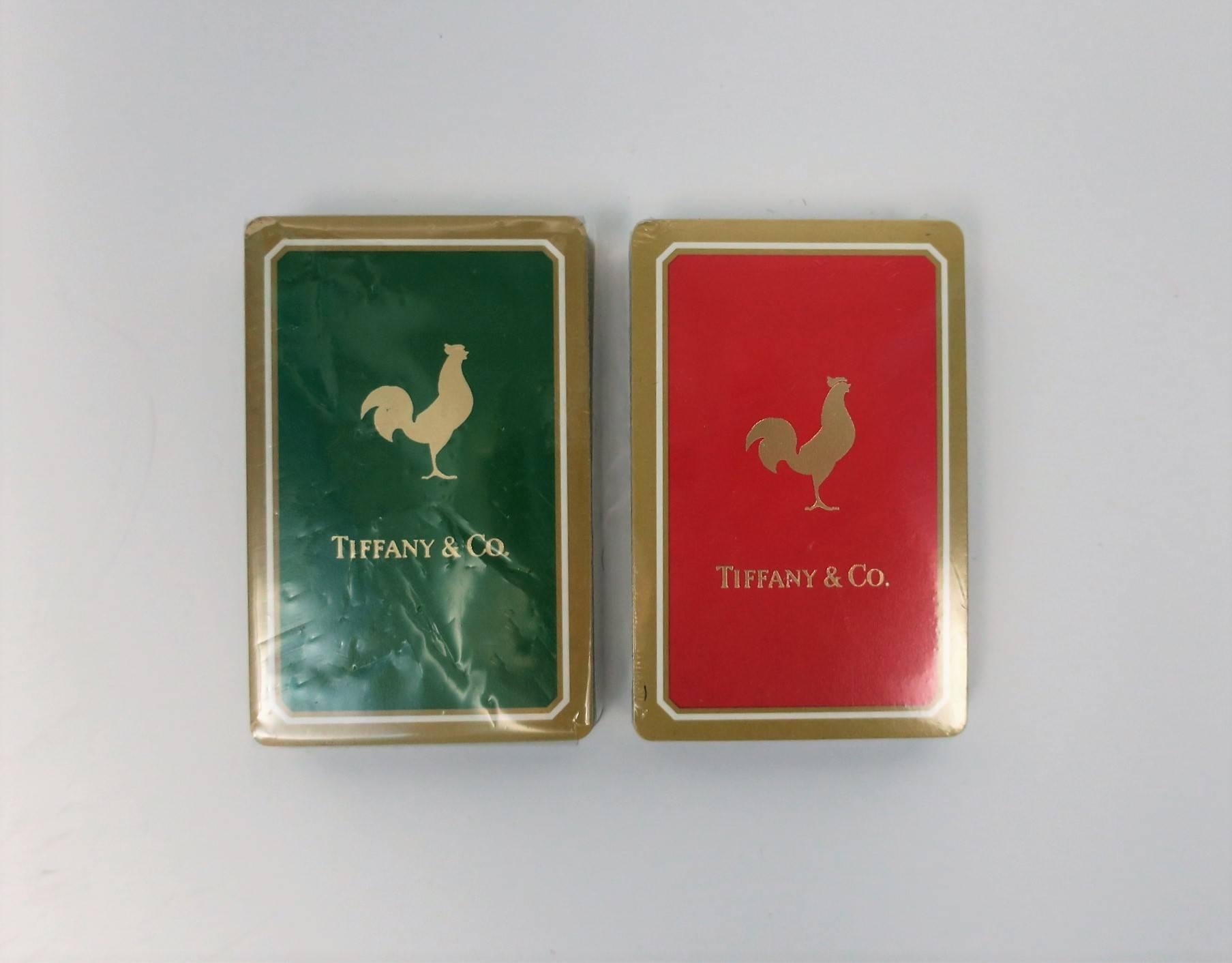 Vintage iconic Tiffany & Co. game playing card set with rooster design. Set contains two decks of cards; one in green and gold, the other, red and gold. Both deck of cards are in original wrapping and have never been used. Set is with original