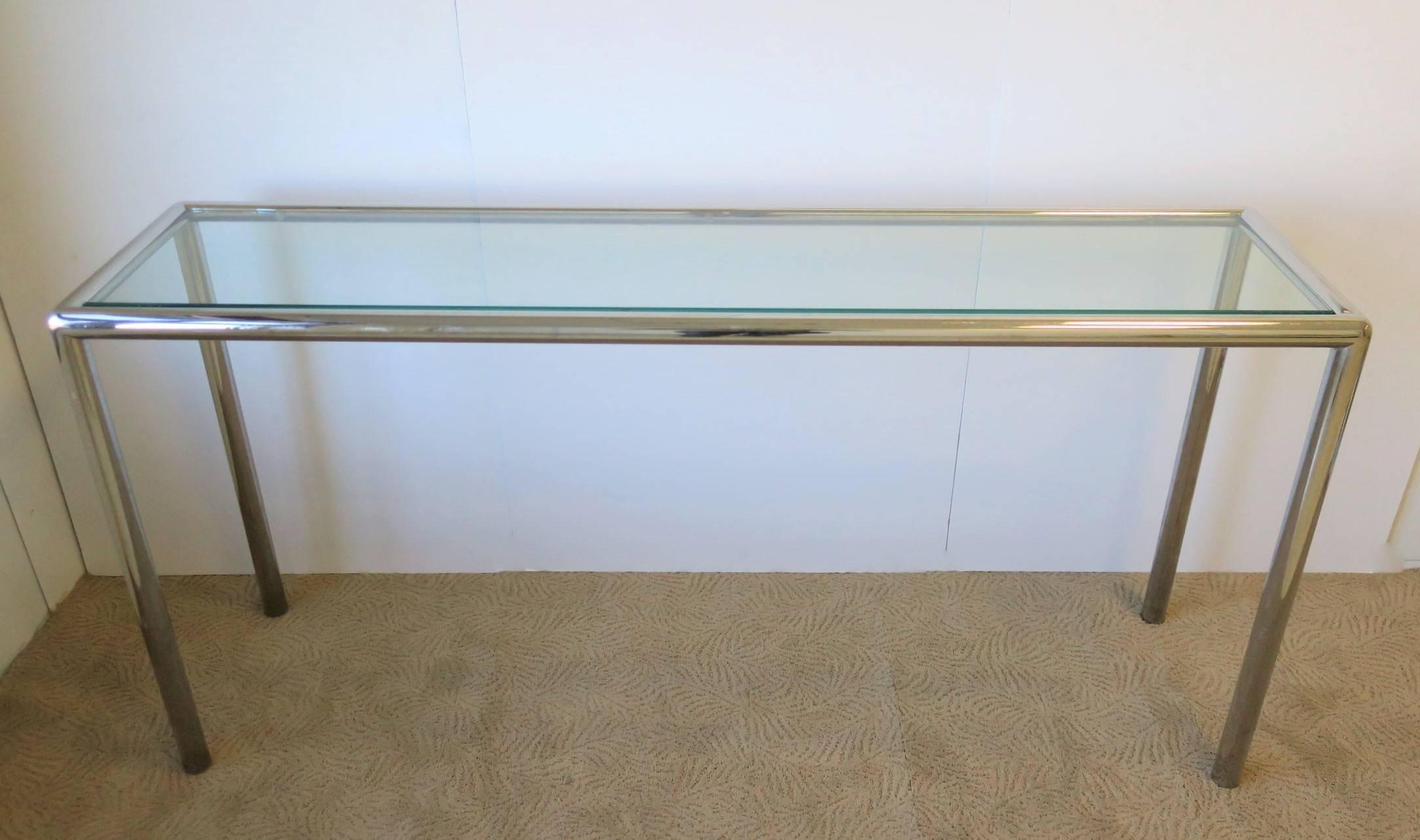 A substantial Modern style chrome and glass console table, circa late 20th Century. Chrome frame is tubular in shape with a substantial inset tempered glass top.

Measurements: 15