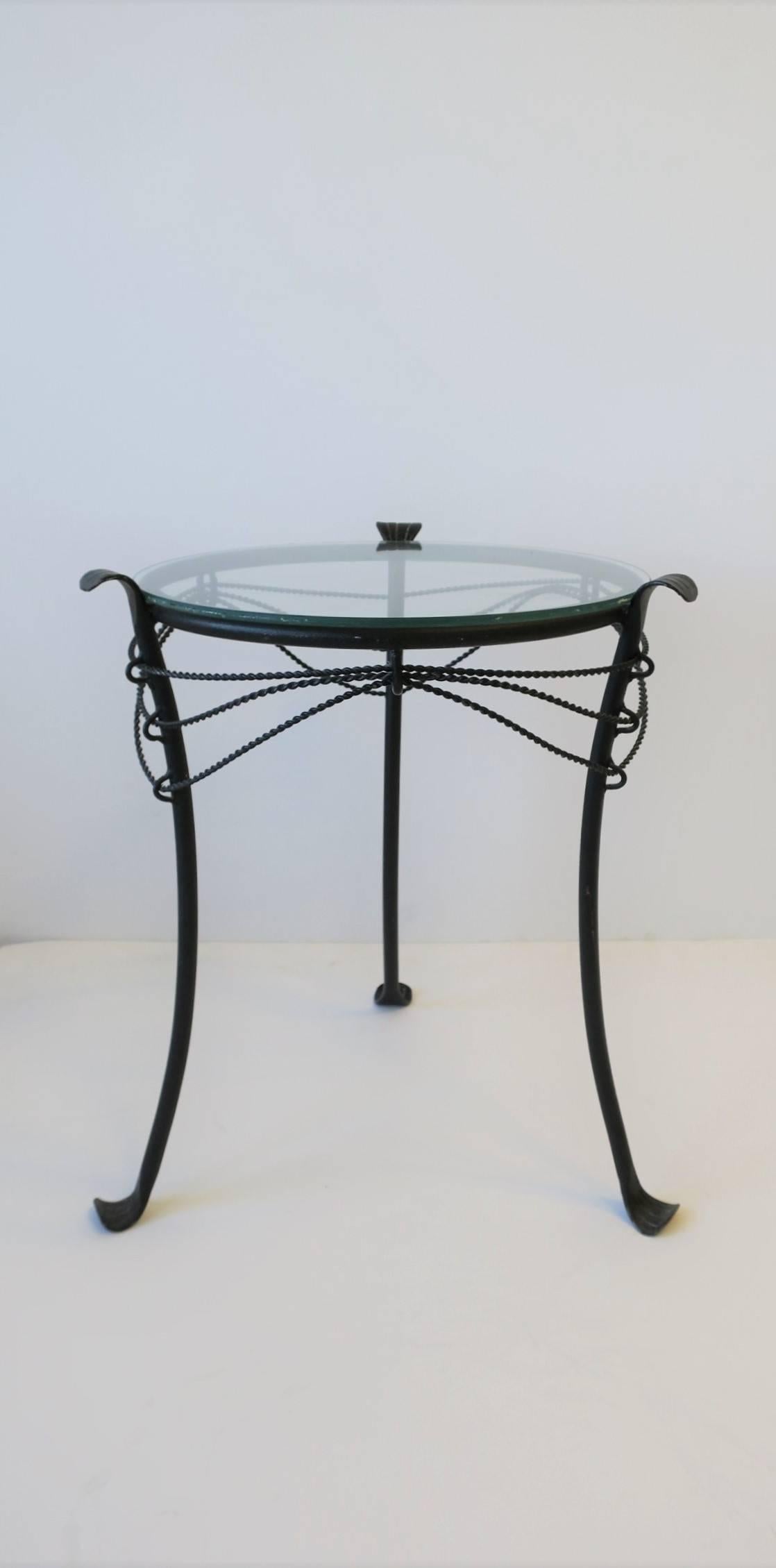 A petite or small Gueridon metal round side table with glass top. Piece can be used indoors or outdoors on a patio, porch, garden area, etc. Shown with two champagne glasses in image #4. 

Table measures:  12