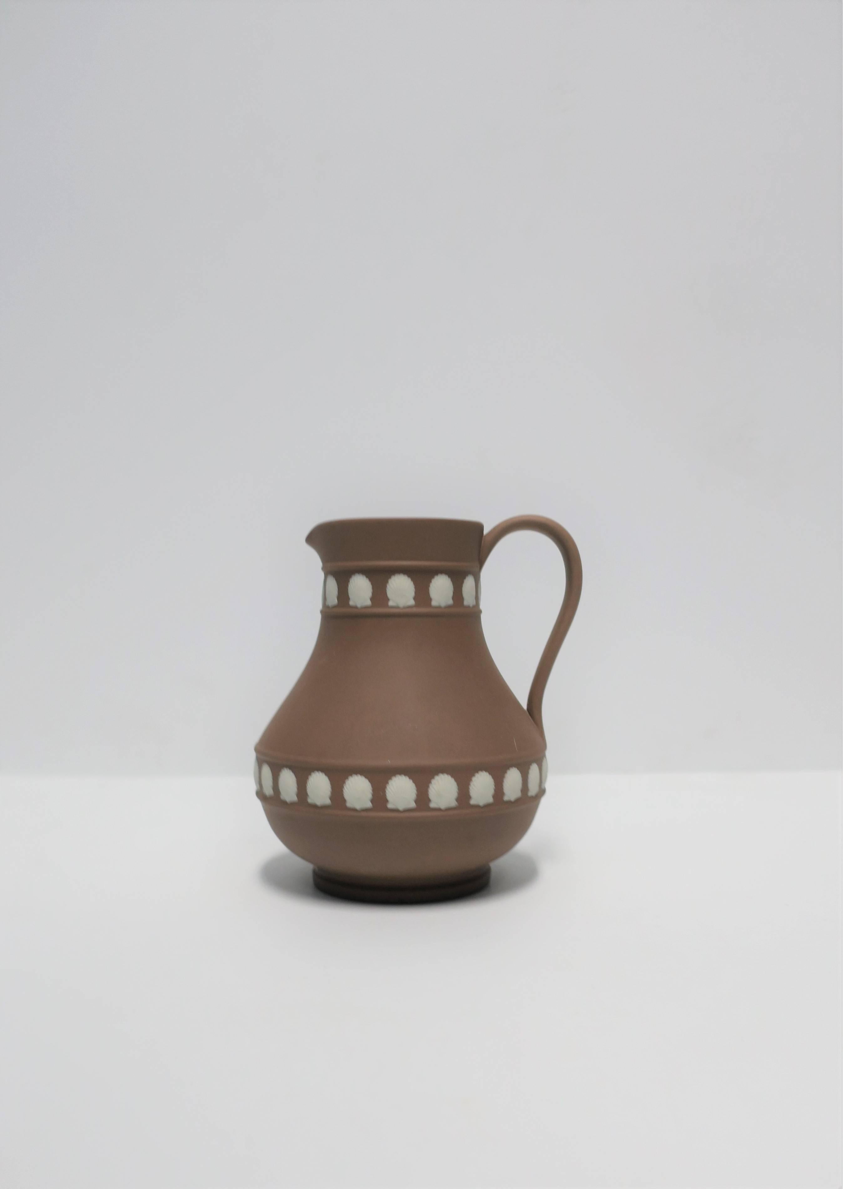 A beautiful Wedgwood Jasperware creamer pitcher with oyster seashell design, circa 1970s England. This piece is a mocha brown or light brown with an off-white oyster seashell design. In image #8 please see maker's mark 'WEDGWOOD', 'Made in England'.