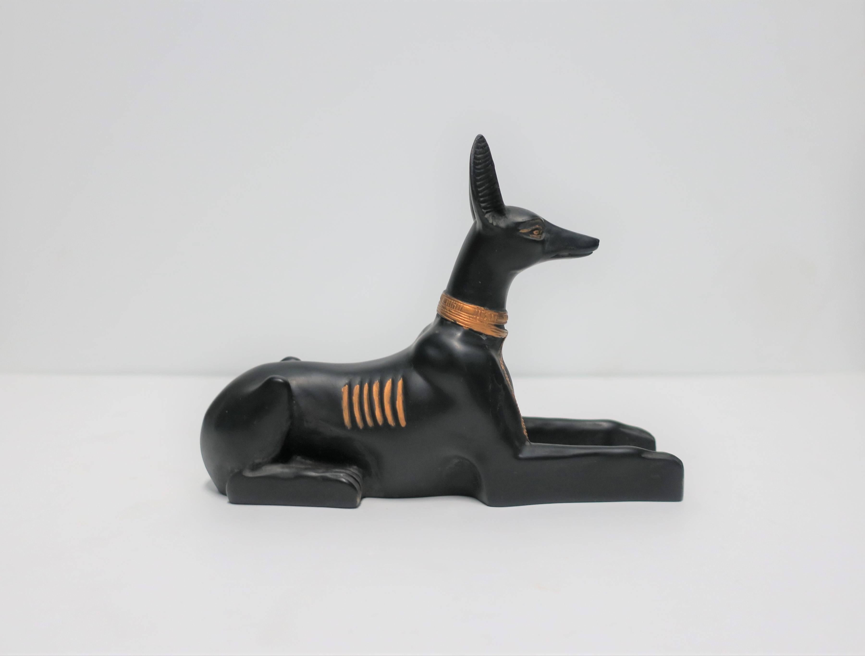 A beautiful and striking vintage black and gold Egyptian 'god' dog sculpture with gold details at neck, ears, eyes and paws. 

Dog measures: 1.75 in. W x 6.25 in. D x 4.75 in. H

