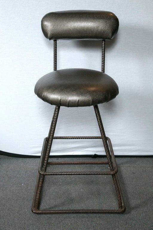Three industrial counter stools whose frame is welded rebar and swivel seats.