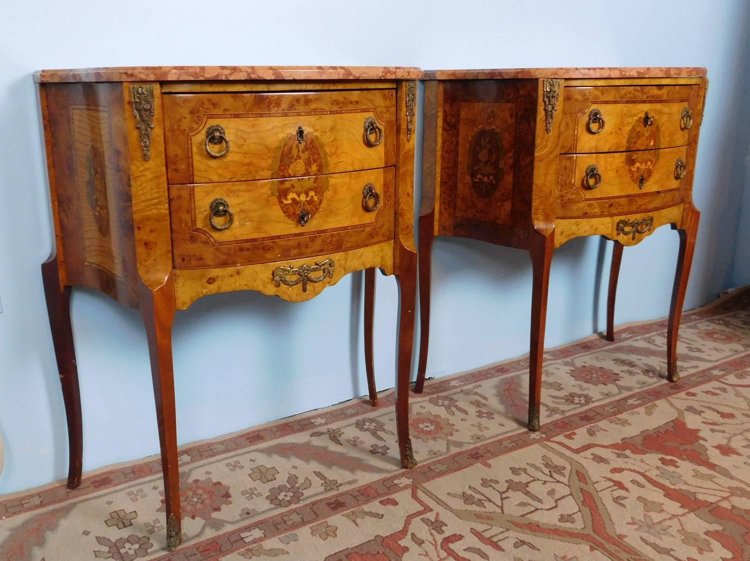 Pair of French inlaid satinwood and bronze mounted two drawer bombe formed side tables, c1930. Shaped rogue marble tops on a case of two banded and inlaid drawers and standing on tall cabriole style legs.