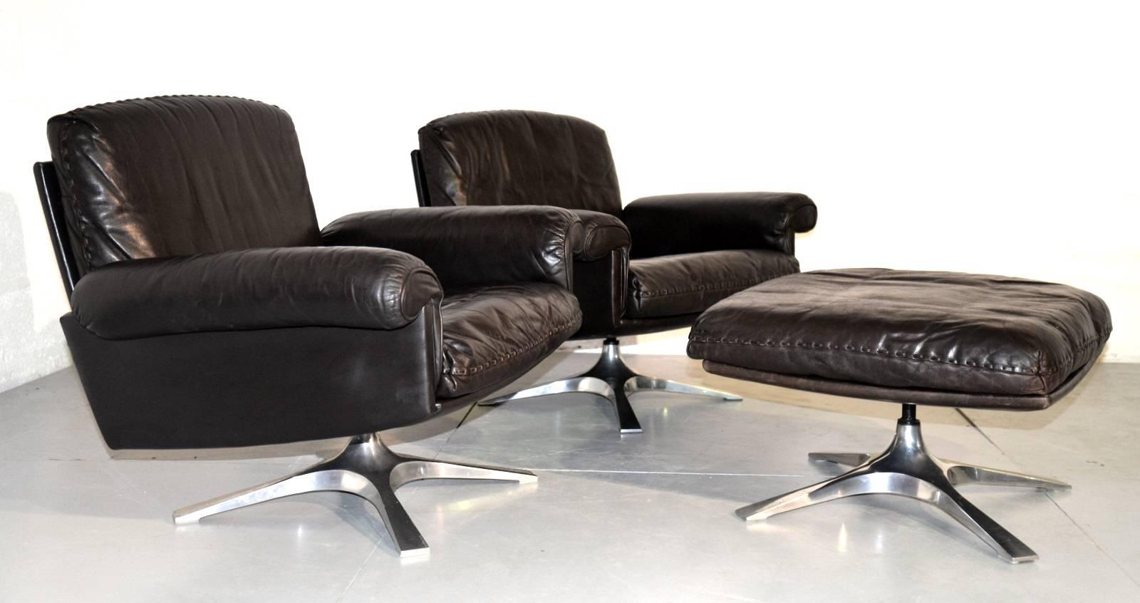We bring you a pair of highly desirable vintage De Sede DS-31 swivel lounge club armchairs and ottoman in beautiful soft dark brown aniline leather with whipstitch edge detail. Standing on a brushed aluminium swivel bases these armchairs were hand