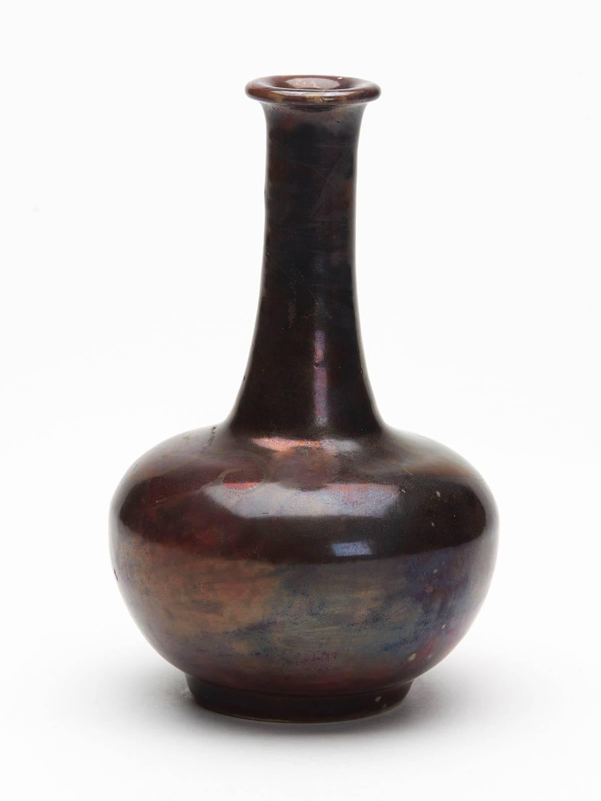 A stylish Arts & Crafts Bernard Moore high-fired luster solifleur vase with a rounded body on a narrow rounded foot with narrow neck and everted rim. The vase is covered in smoked black luster and copper glazes over a flambe red ground with a