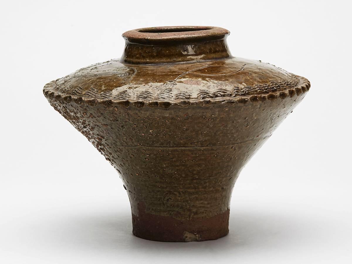 An antique Korean Joseon dynasty pottery vase of wide rounded form with a narrow rounded top and with a narrow rounded cylindrical shaped lower body. The vase is decorated in green glazes and is incised with two birds and other designs around the