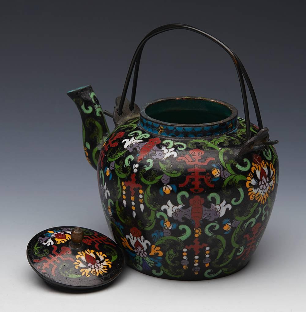 An antique Chinese Qing cloisonné lidded wine pot decorated with stylized moths, scrolling floral designs and shou emblems and signed Tong Shun Tang (Hall of Common Agreement) to the base dating from the 19th century. The wine pot is of rounded