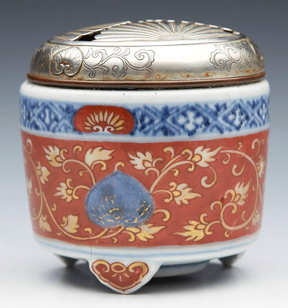 We offer this stunning antique Japanese Arita silver topped censer decorated with scrolling leaf stems and fruit designs in the Imari palette and dating from the 18th century. The finely made porcelain censer stands raised on three moulded leaf