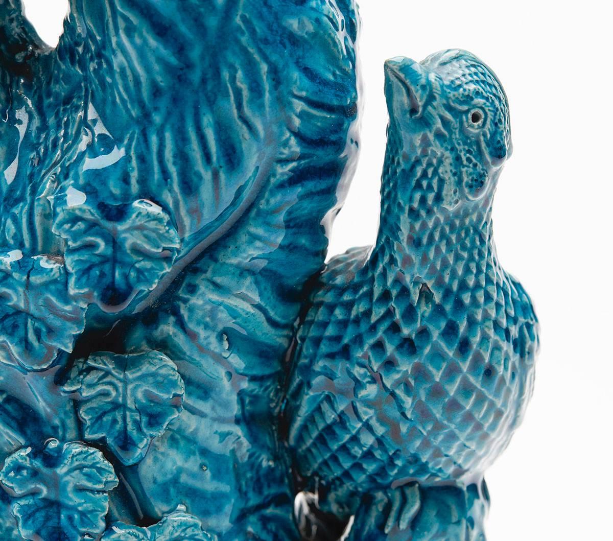 A fine antique Chinese vase modeled as a tree stem applied with leaves with a male and female pheasant like birds perched on branches and looking at each other. The vase is decorated in deep turquoise blue glazes and has an unglazed base and is not
