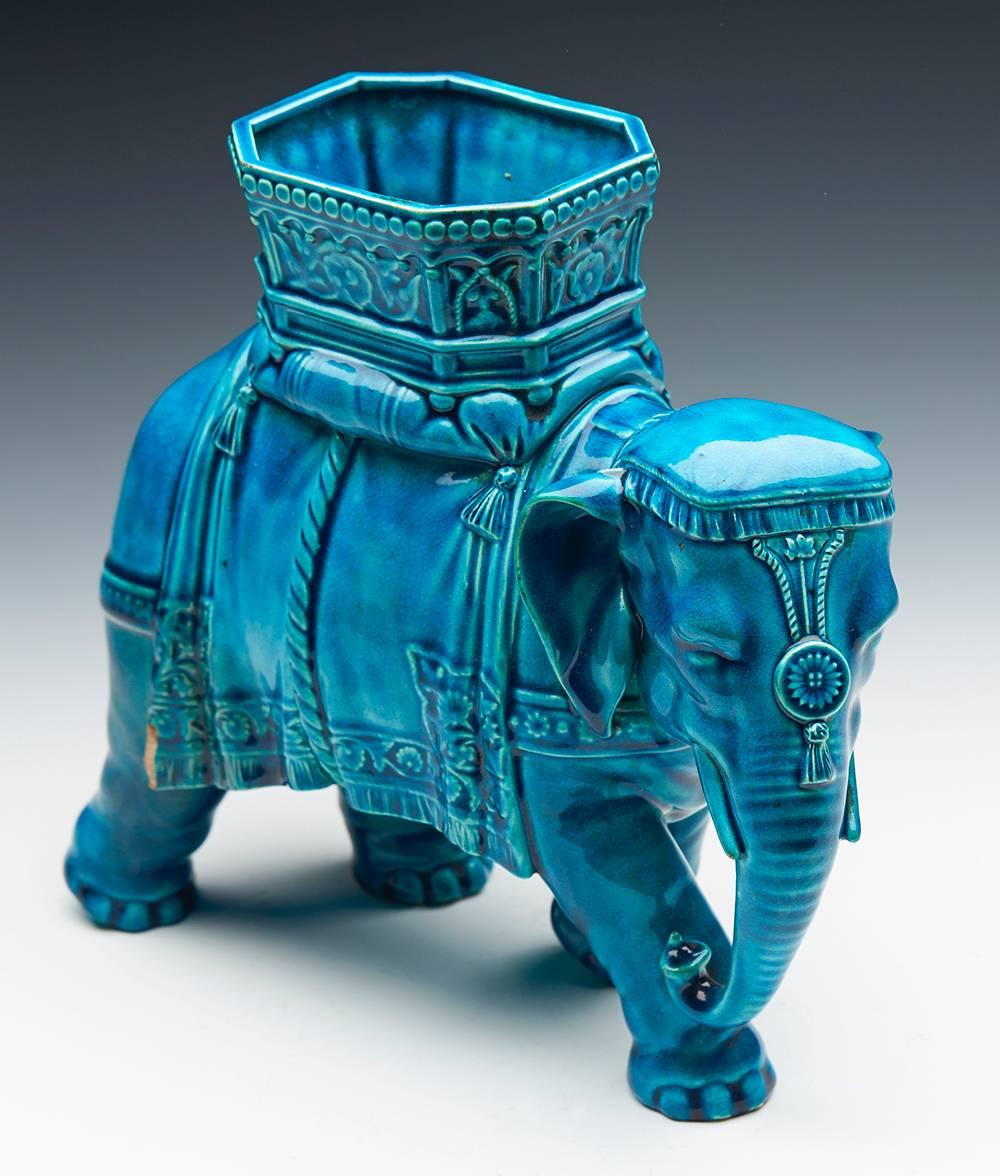 An antique Royal Worcester majolica vase in the form of an elephant with a howdah modelled by James Hadley and dating from circa 1875. The earthenware vase is modeled as a large dressed elephant with a howdah on its back and decorated in rich dark