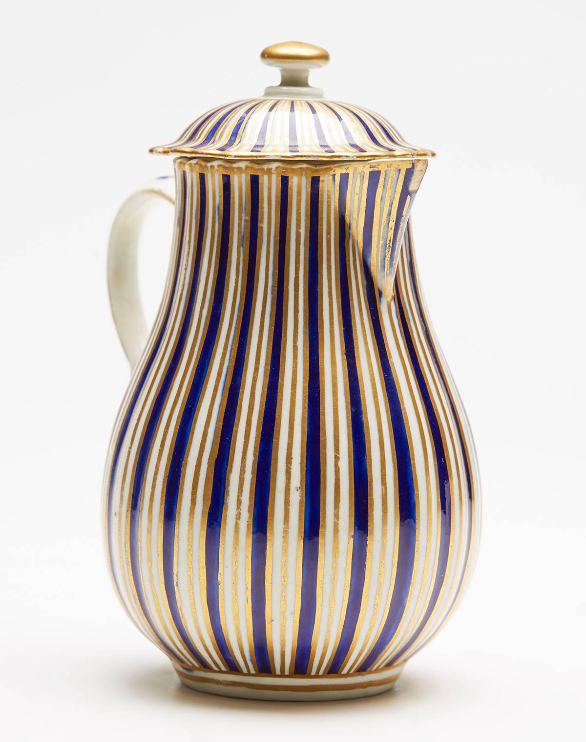 A very fine antique English porcelain sparrow beak jug and cover decorated with a blue and gilded stripe design. The finely made jug has a moulded ribbed body and cover with a loop kicked handle. The jug is not marked