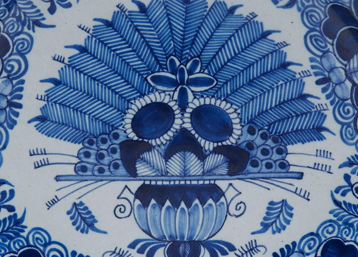 A fine antique Dutch Delft plate hand-painted in underglaze blue with the peacock design, the rim painted yellow. The earthenware plate has a blue painted makers mark to the base.