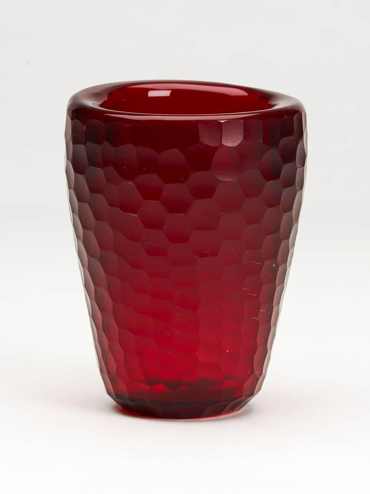 A stunning vintage Italian Murano 'battuto' red art glass vase of small rounded cylindrical shape with a thick glass body with honeycomb cut design attributed to Carlo Scarpa for Venini. The vase has a flat polished base and was acquired as part of