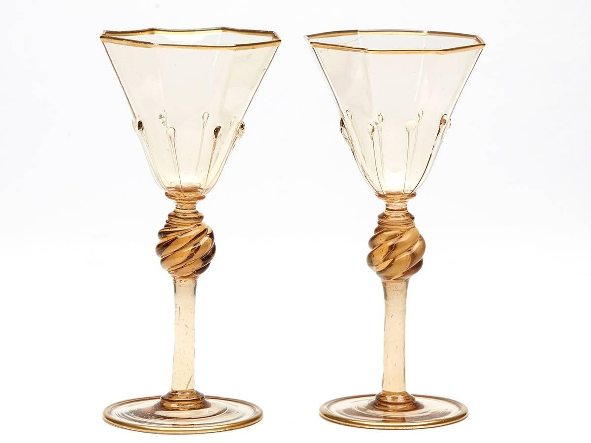 A very fine pair Murano MVM Cappellin amber liquer glasses with octagonal bowl with applied tear drops to a wrythen knopped stem and spreading circular foot and with gilded edging. The glasses are not marked.

MVM Cappellin & C. was founded by