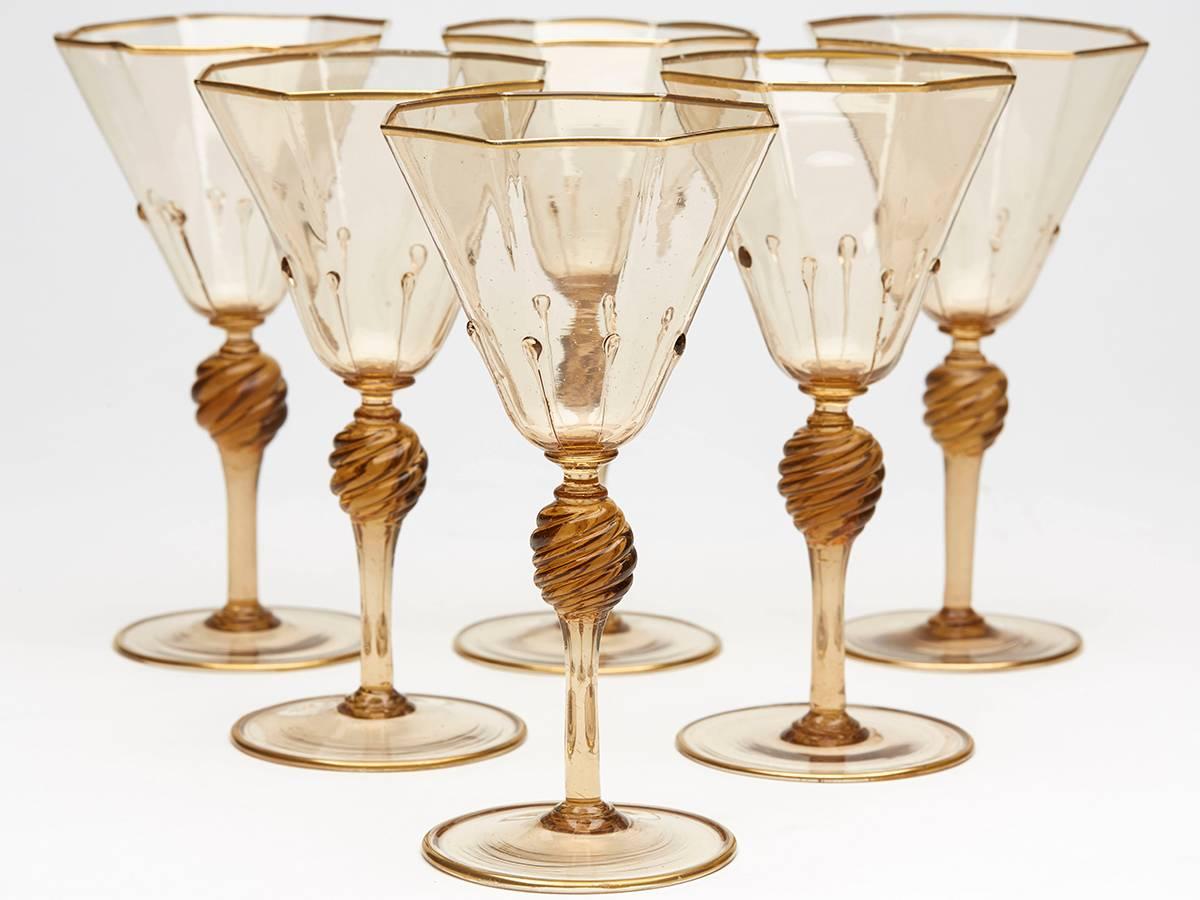 A very fine set of six Murano MVM Cappellin amber wine glasses with octagonal bowl with applied tear drops to a wrythen knopped stem and spreading circular foot and with gilded edging. The glasses are not marked.

MVM Cappellin & C. was founded by