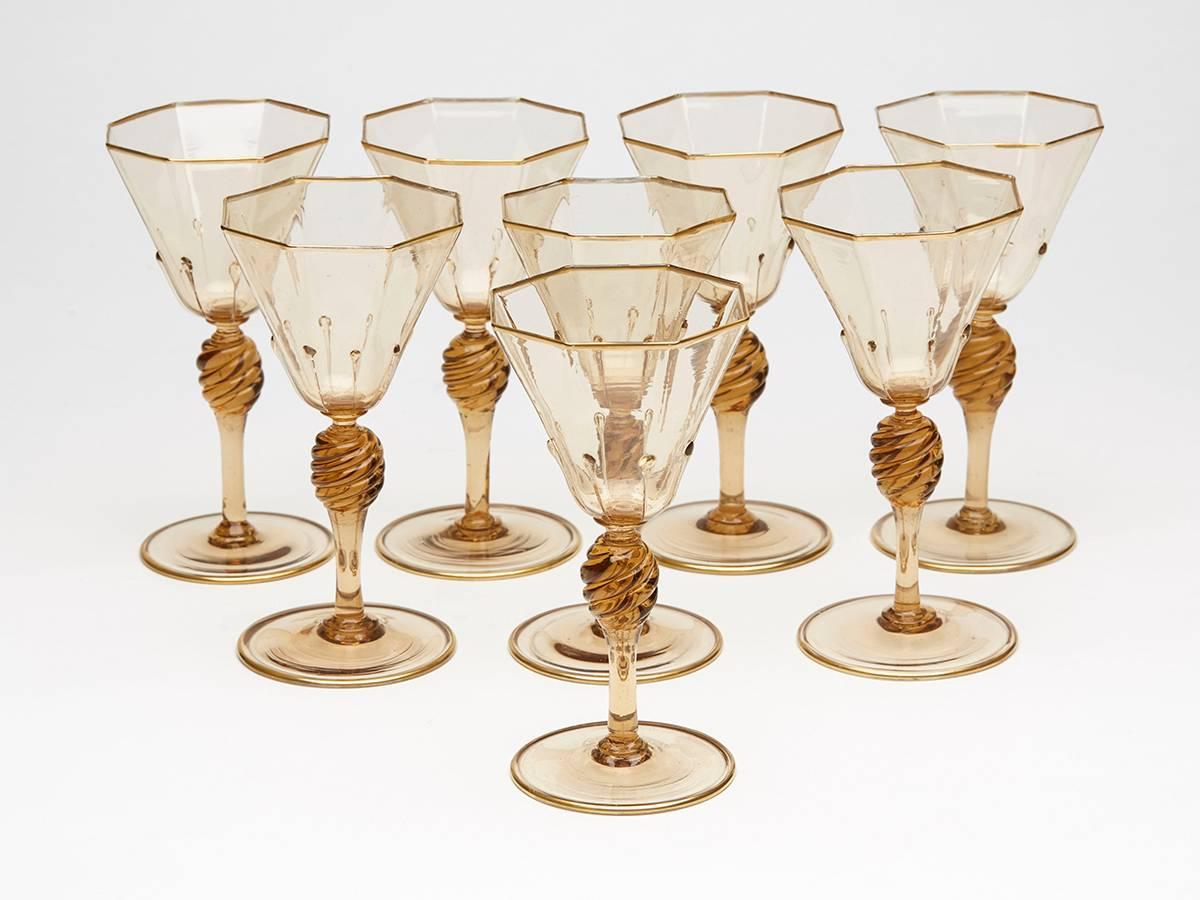 A very fine set eight Murano MVM Cappellin amber wine glasses with octagonal bowl with applied tear drops to a wrythen knopped stem and spreading circular foot and with gilded edging. The glasses are not marked.

MVM Cappellin & C. was founded by