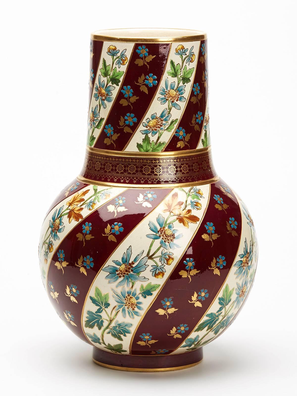 A large and stunning antique French Sarreguemines art pottery vase hand-painted with floral designs on a mauve and cream coloured banding with gilded highlights. The vase stands on a narrow rounded foot with a large rounded bulbous body and wide