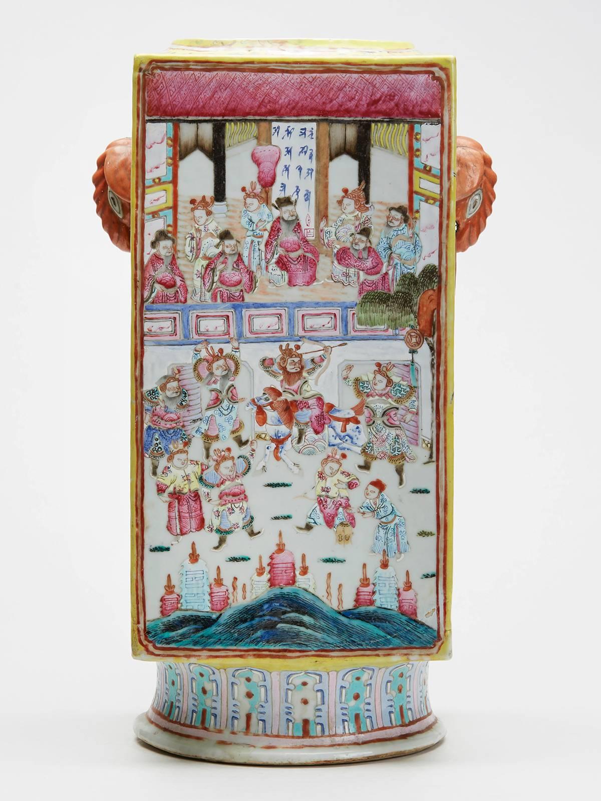 A large and impressive antique Chinese cong shaped vase of square sided form standing on a rounded skirted foot with elephant and ring handles applied either side. This heavily made porcelain vase is decorated in the famille rose palette with