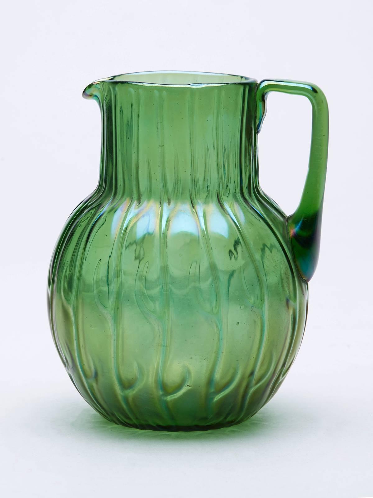 A stunning Art Nouveau bohemian art glass 'Neptun' green iridescent jug by Loetz. This stylish jug has a moulded design with handle to the side and polished pontil mark to the base and is not marked.

Provenance: From a vast single owner glass