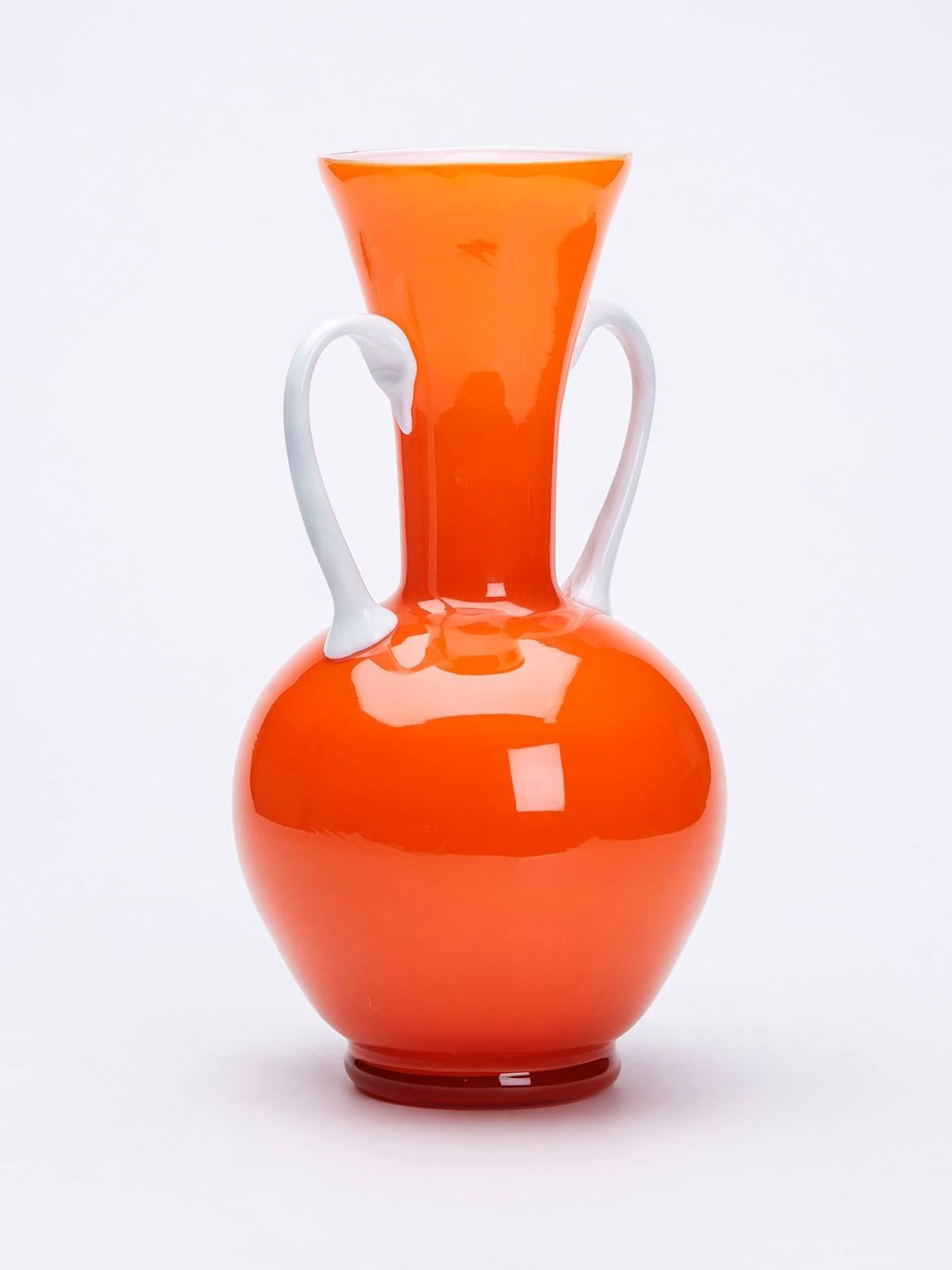 A stunning Mid-Century Italian, Empoli attributed twin handled orange cased glass vase with white glass interior and handles. The vase is not marked.