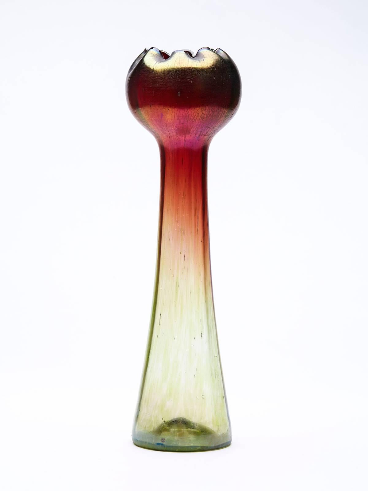 An Art Nouveau tall Bohemian 'Pepita' hyacinth are glass vase by Rindskopf. The vase has a moulded panel body forming a tall stem with a rounded flower or bud shaped top. The vase has a green coloured lower body extending upwards into a wine red