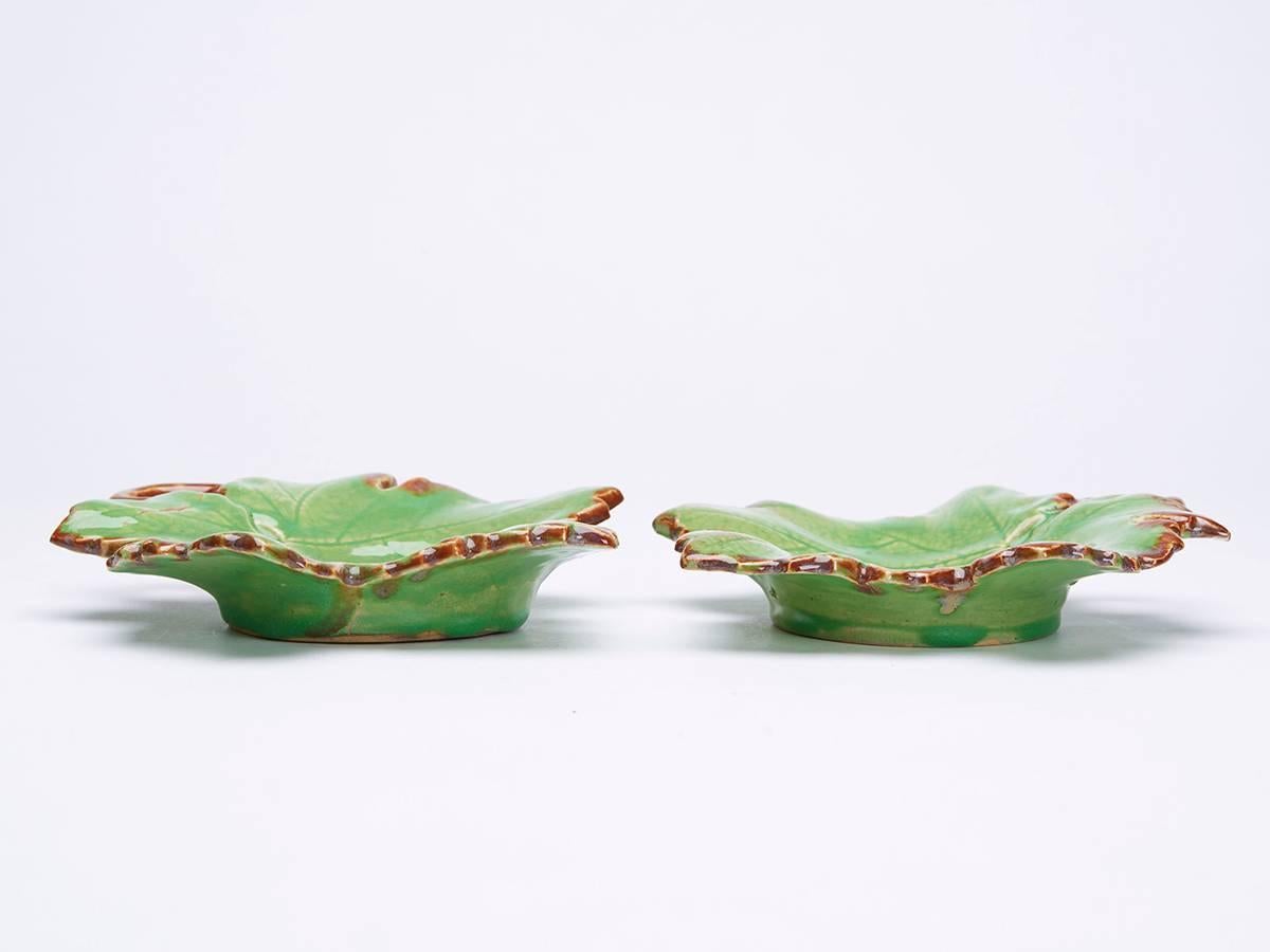 A pair of French Greber art pottery dishes modeled as leaves, the stems forming handles decorated in green and brown glazes with Fine surface veining. Made in Beauvais and probably by Charles Greber (1853-1935) the stoneware dishes Stand on a