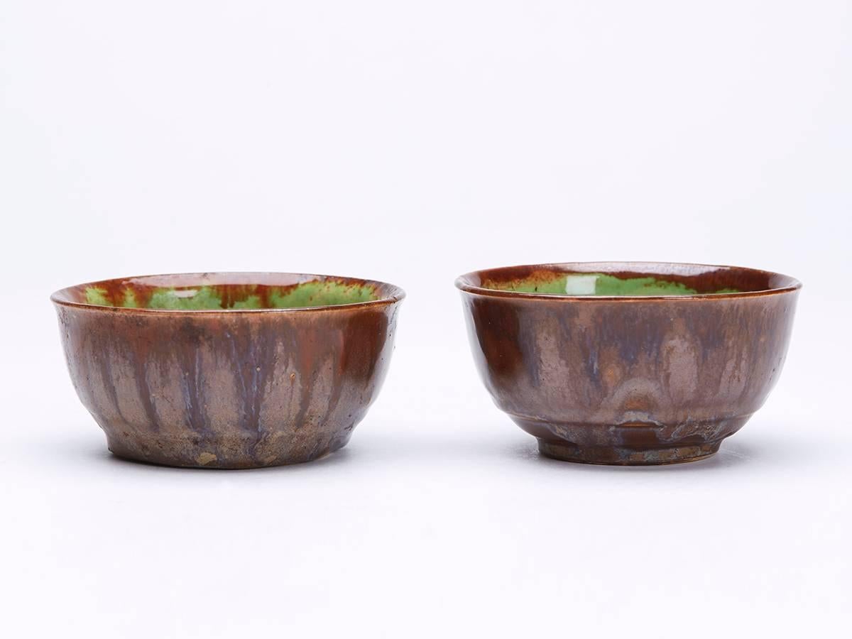 A stunning set four French Greber art pottery bowls of rounded form with a raised ridge above a narrow rounded unglazed foot. The stoneware bowls are decorated in brown mottled glazes run over the top edge with green glazes to the inside of the