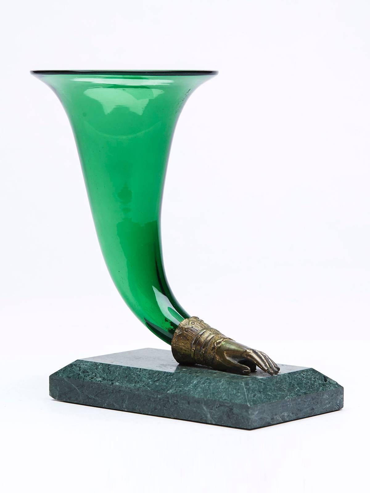 A very fine and stylish antique green glass cornucopia vase mounted in a cast brass hand mounted on a polished green marble base. The vase is not marked.