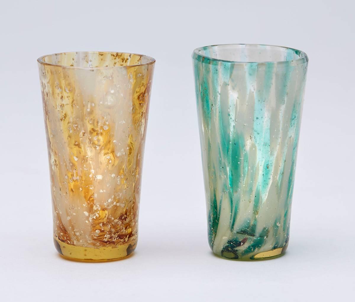 A scare and unusual set six Bohemian miniature tumbler shaped spirit glasses each with a white and colored spatter designs with fine Mica inclusions believed to be made at Kralik. With a slight tint to the glass bodies, the glasses are not marked.
