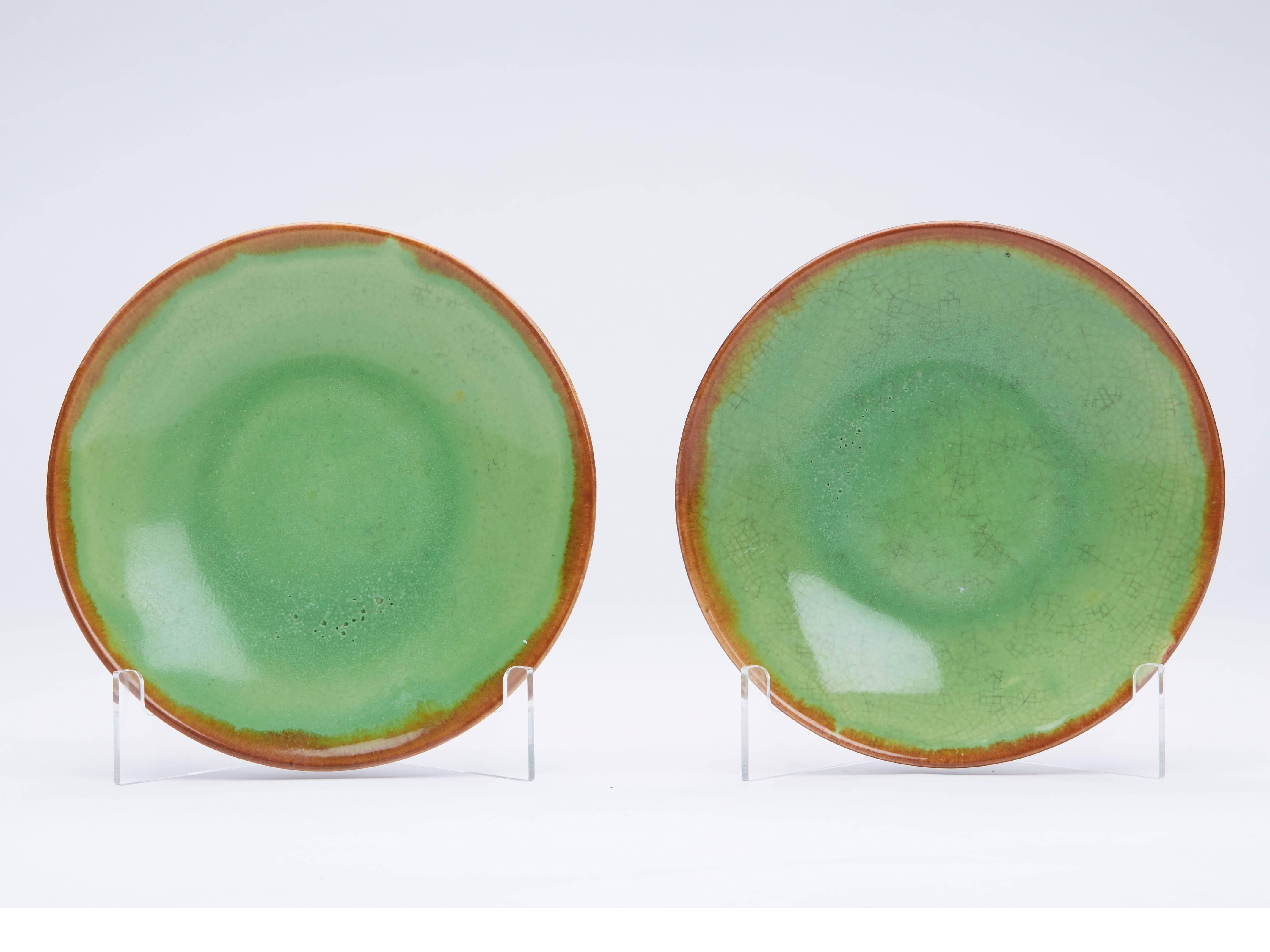 A stylish French Greber art pottery set of seven stoneware plates decorated in green glazes with mottled brown glazes applied to the underside of the rim and flowed over the top. Made in Beauvais and probably by Charles Greber (1853-1935) the plates