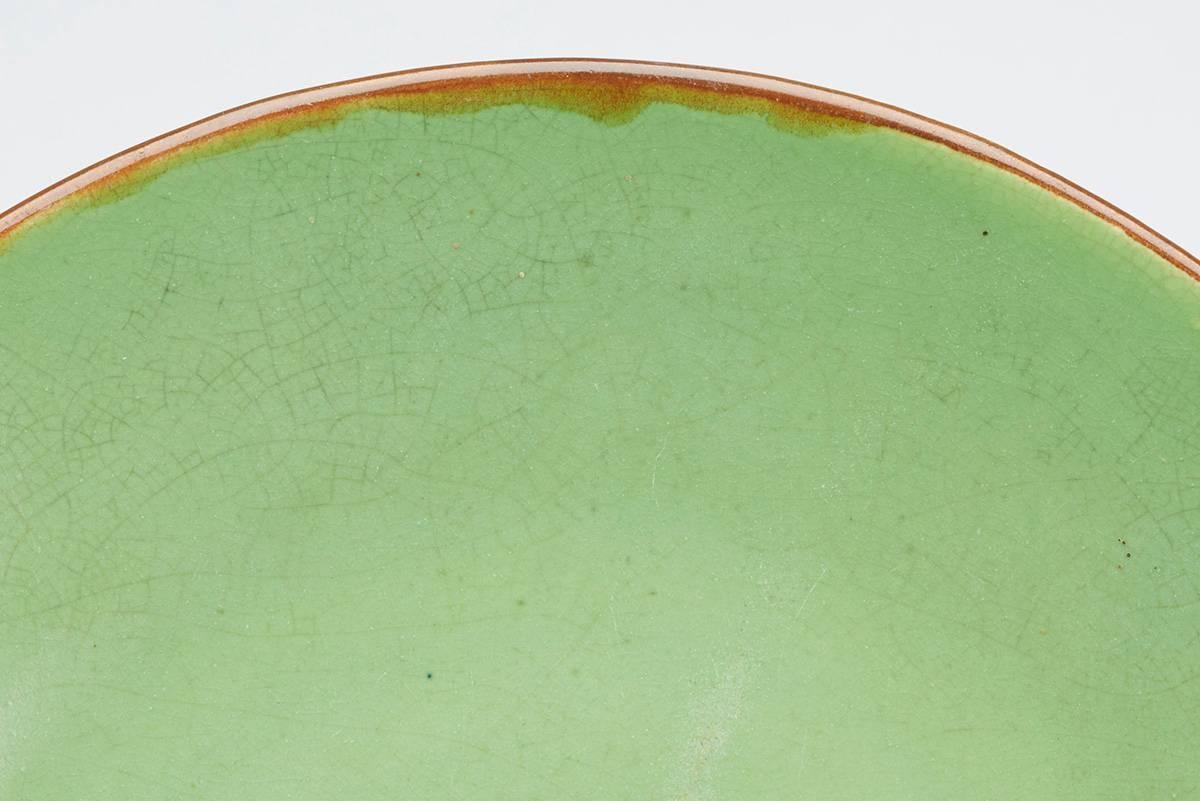 A rare Charles Greber art pottery plate decorated in bright green glazes with a brown glazed rim made at Beauvais, France. The heavily potted earthenware plate is of simple rounded form with impressed Greber signature mark along with impressed