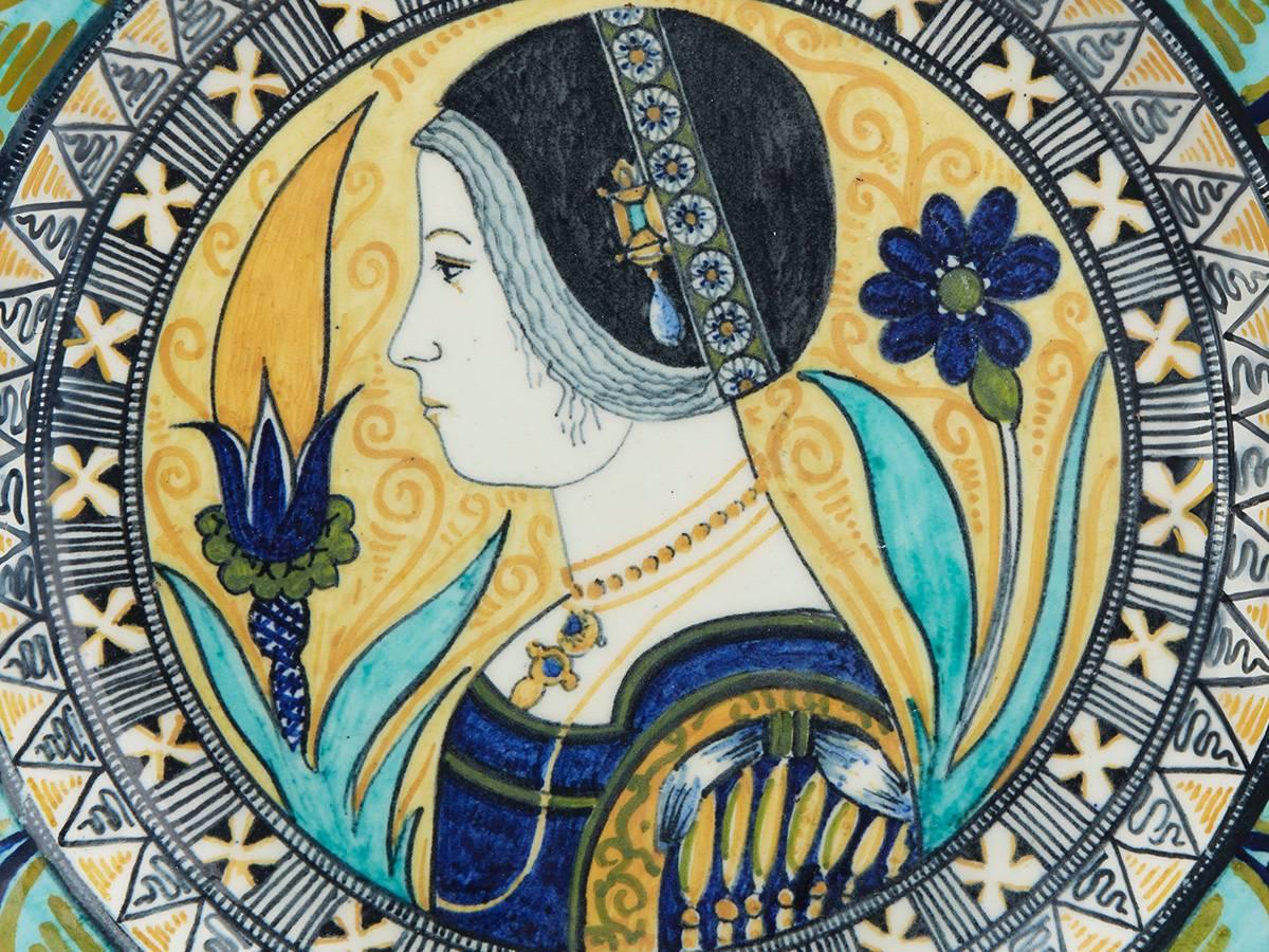 An exceptional Renaissance Revival Maiolica tin-glazed plate painted with a side profile portrait of a lady within a decorative border with a line painted design to the base. The lightly potted earthenware plate is hand-painted in blue, yellow,